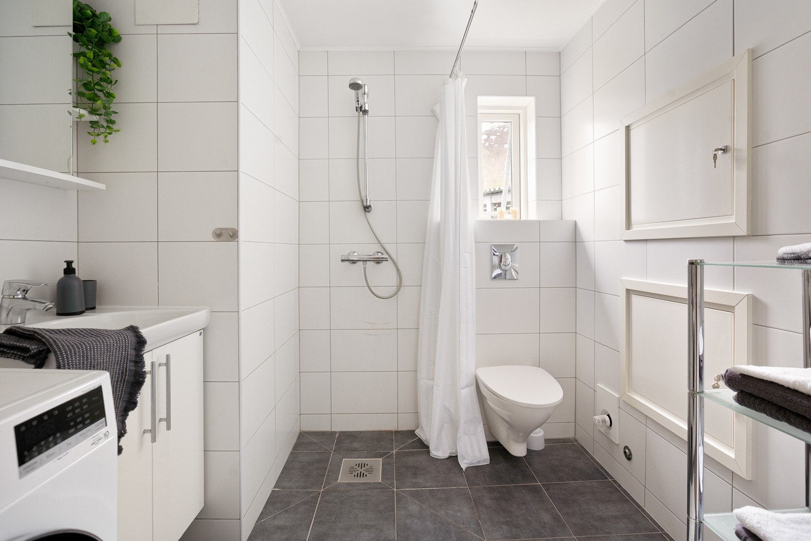 Flislagt bad med god plass for vaskemaskin. Galleribilde