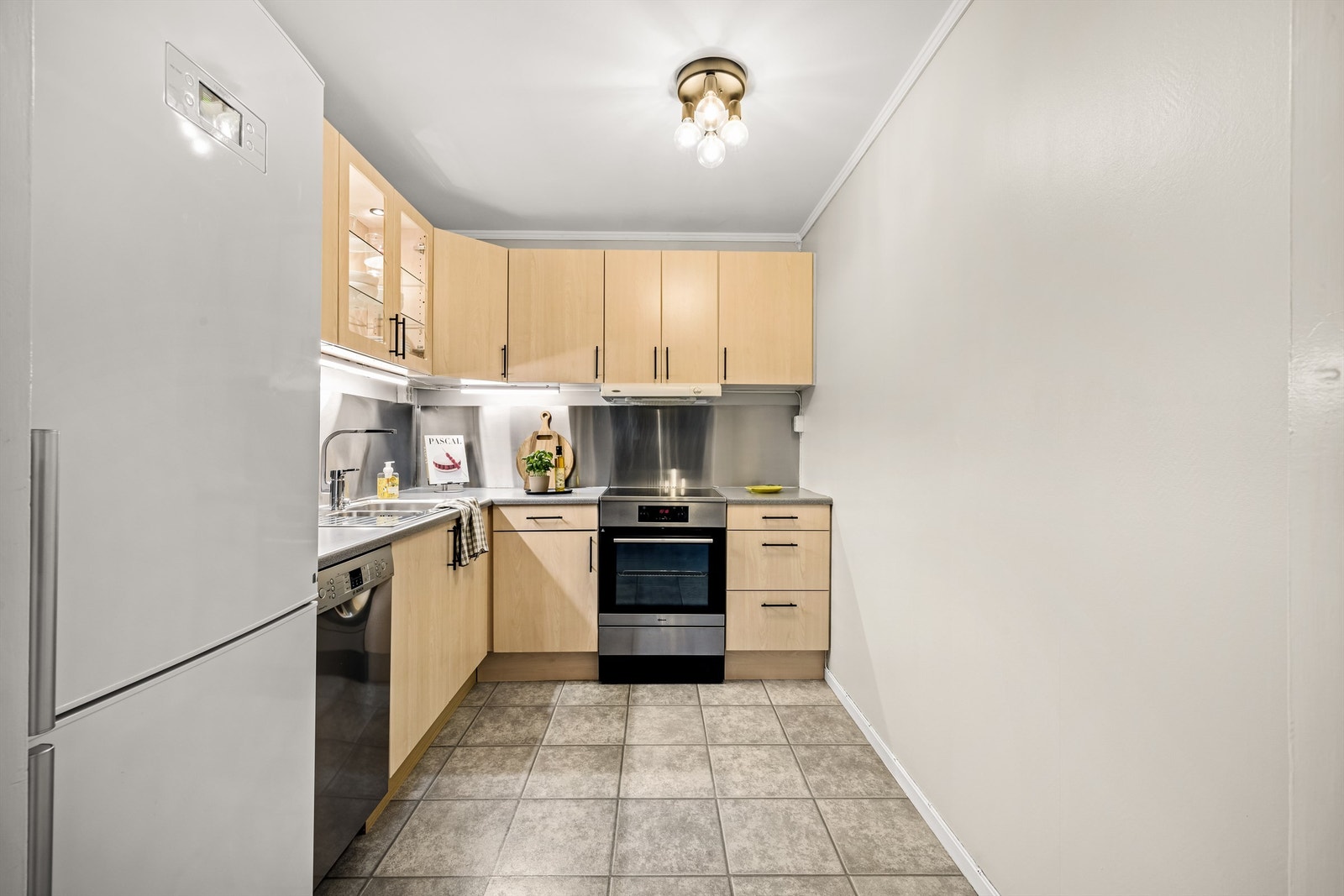 Kjøkkenet har velholdt innredning og et robust, praktisk gulv i laminatflis. Galleribilde