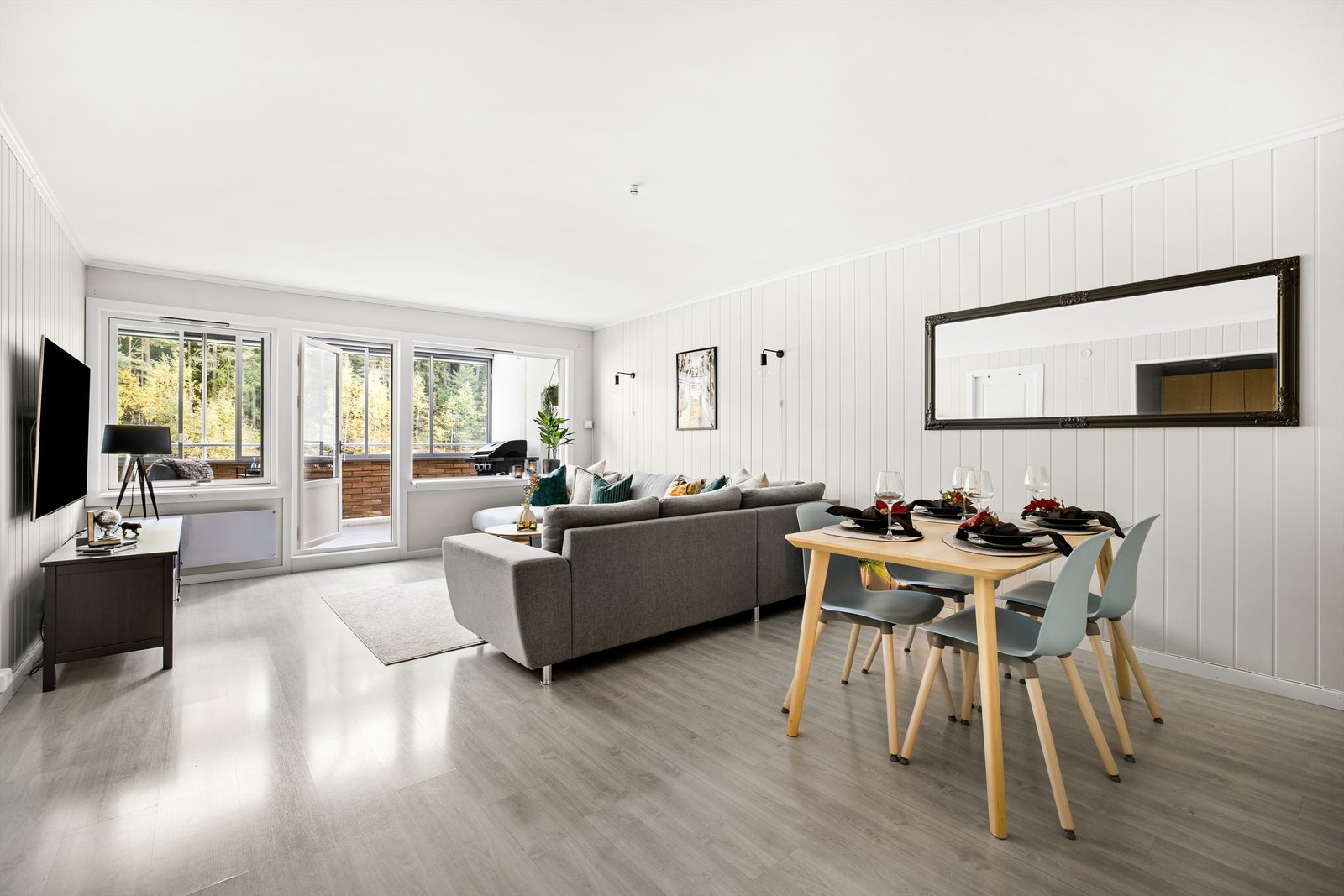 Fint utsyn til skog og mark sees fra både sofakroken og spisebordet innerst i stuen. Galleribilde