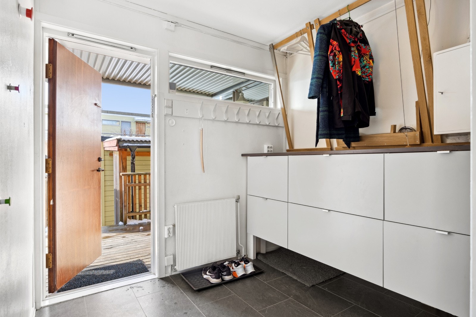 Forbi inngangsdøren blir man møtt av en romslig entré med god plass til oppbevaring av klær og sko. Galleribilde
