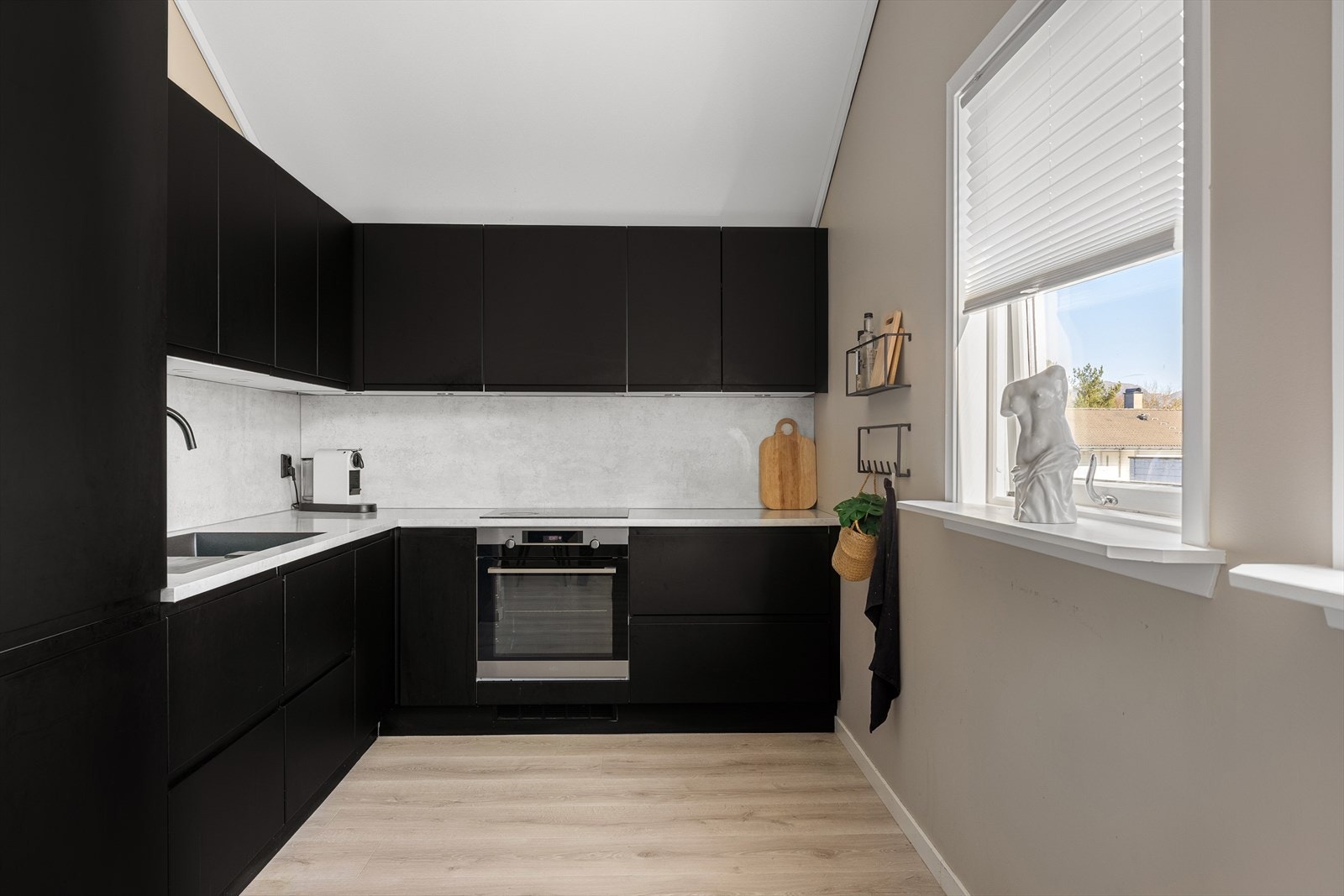 Kjøkkenet er fullt utstyrt med integrerte hvitevarer, inkludert induksjonsplatetopp, stekeovn, oppvaskmaskin, kjøl- og fryseskap. Det er god skap- og benkeplass for matlaing og oppbevaring. Galleribilde