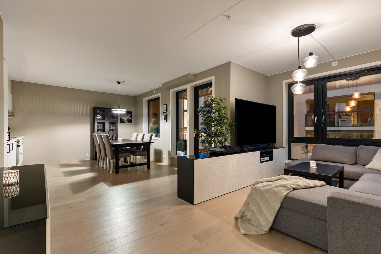 Tiltalende stue med 1-stavs parkett på gulv og malte sletter flater på vegger og i himling Galleribilde