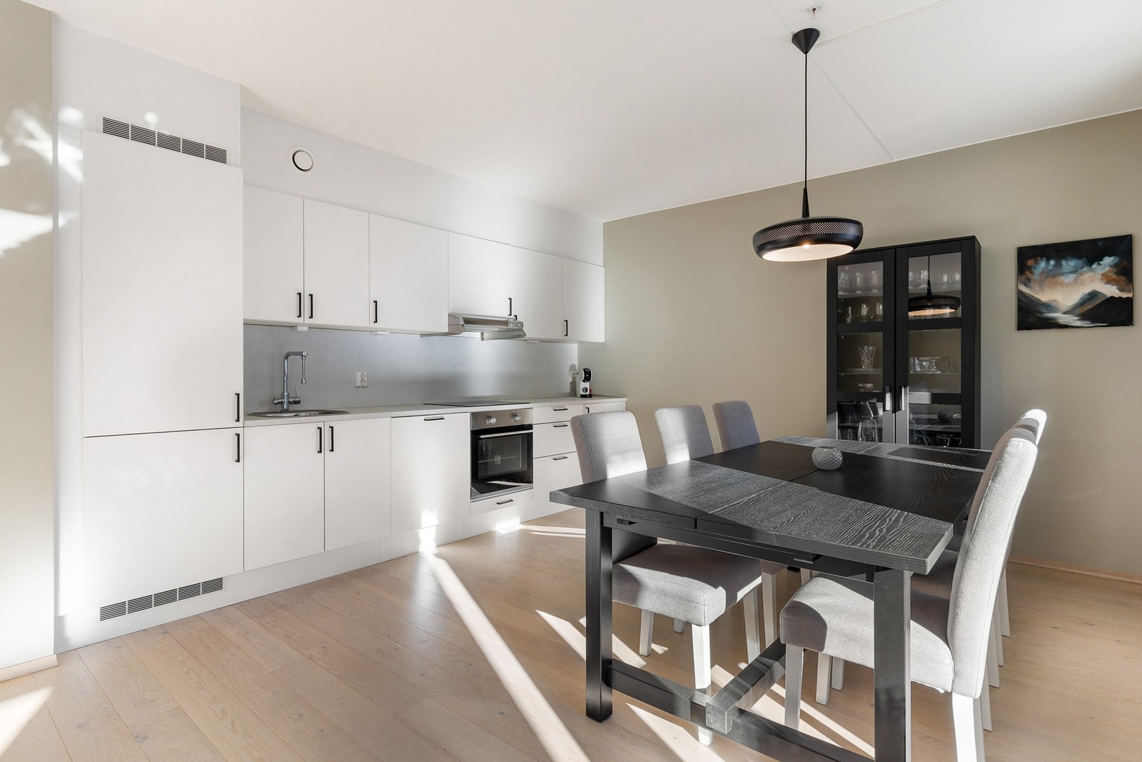 Pen kjøkkeninnredning med slette fronter og laminert benkeplate med nedfelt kjøkkenkum og ett-greps blandebatteri Galleribilde