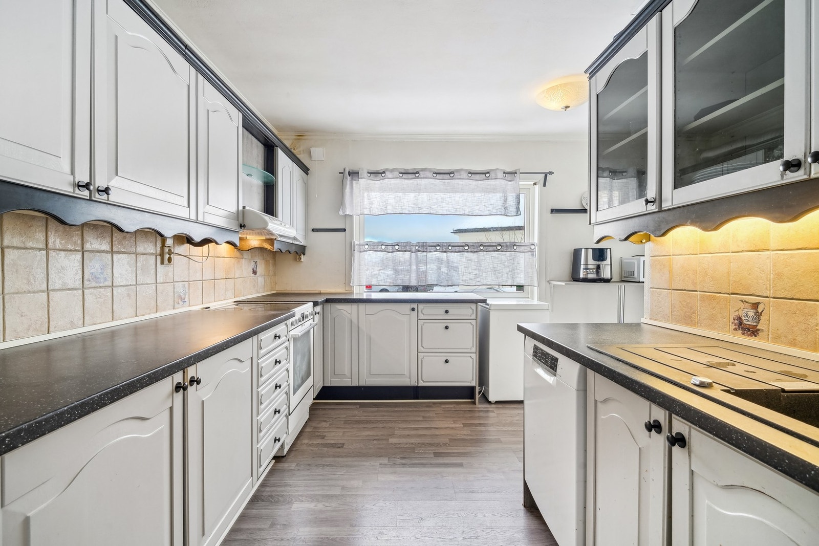 Tidløst kjøkken med hvite profilerte dører. Galleribilde