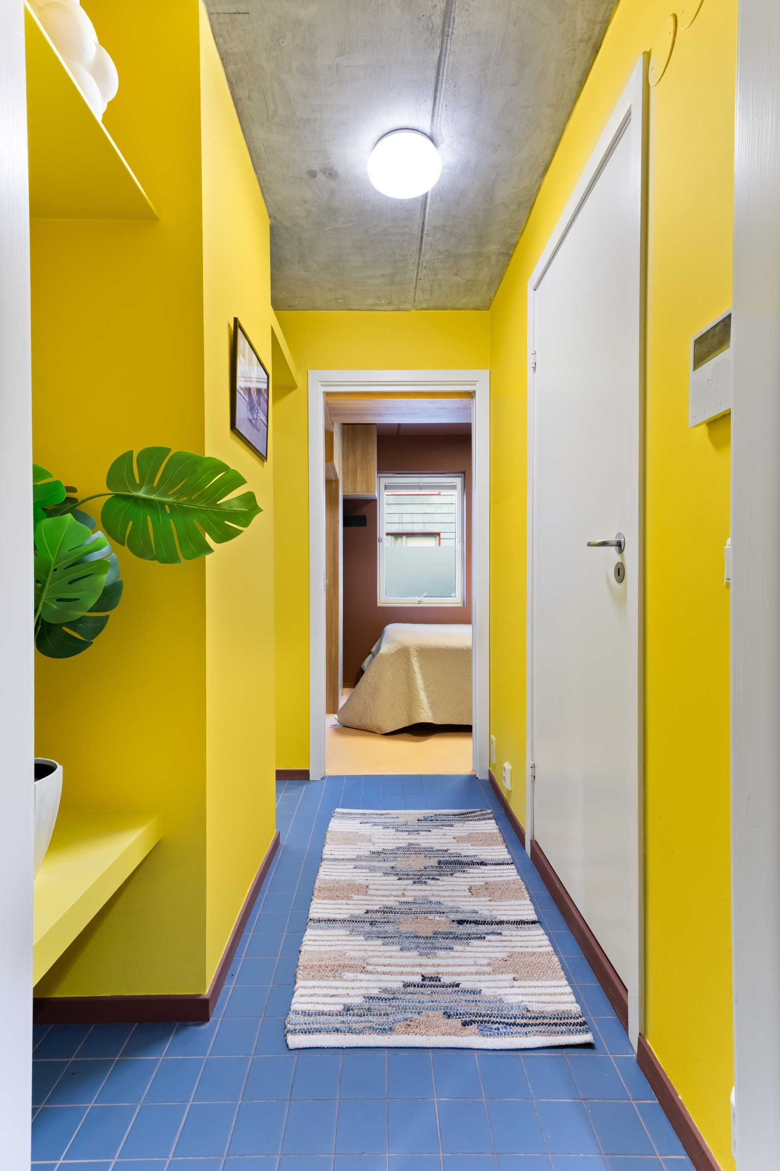 Små blå fliser på gulvet gir et elegant preg og harmonerer perfekt med de friske gule veggene Galleribilde