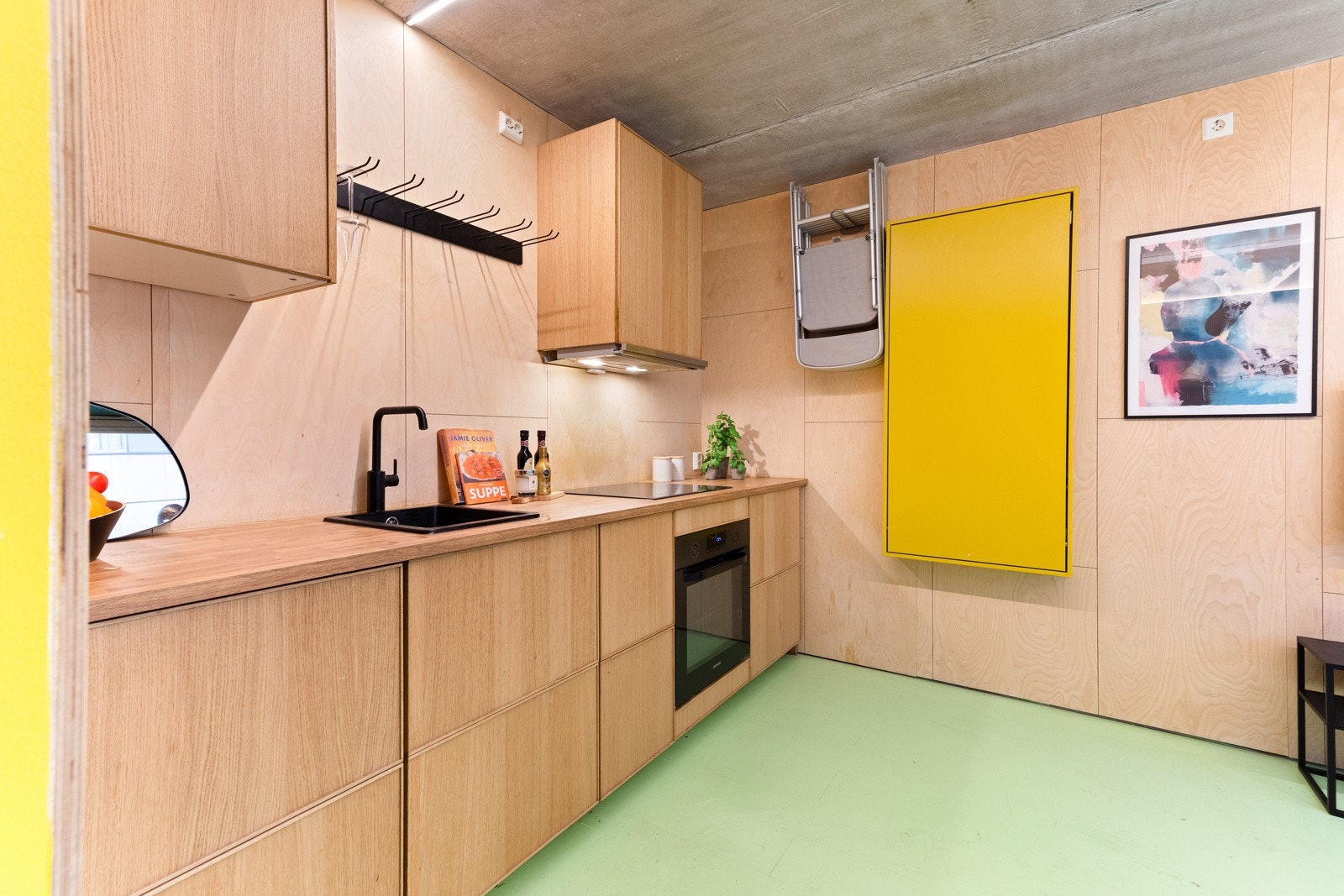 I tilknytning til kjøkkenet finnes et oppfellbart bord og oppheng for fire kjøkkenstoler, som gir fleksibilitet og maksimerer bruken av rommet. Galleribilde