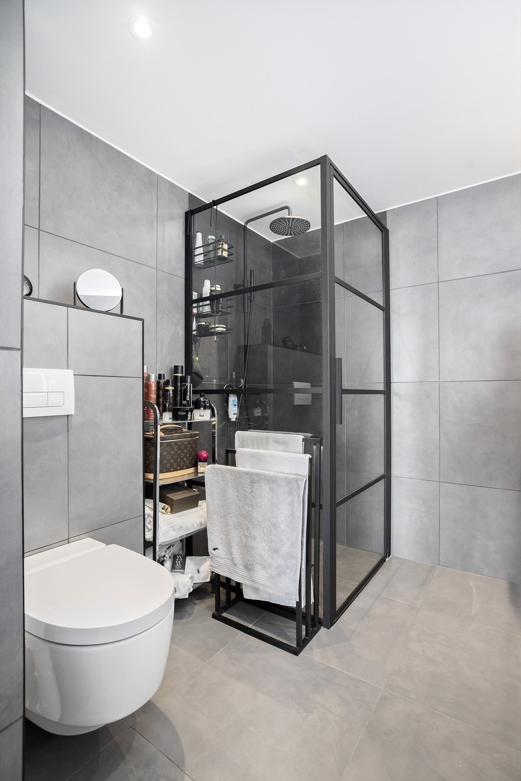 Master bad er utstyrt med dobbel servant over skuffinnredning samt dusjhjørne og vegghengt toalett Galleribilde