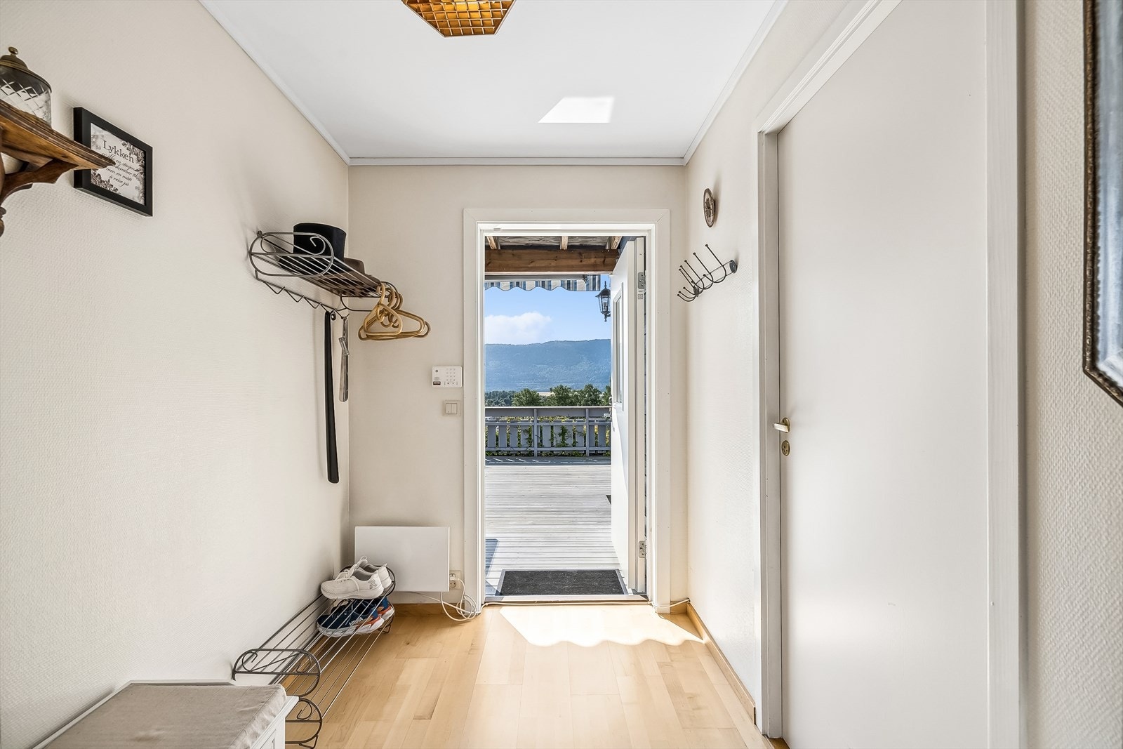 Lys og pen gang med plass til å henge fra seg yttertøy og plassere sko. Galleribilde