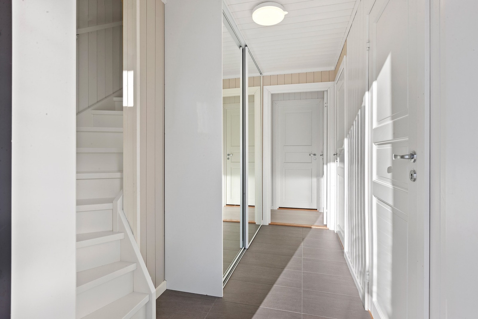 Lys gang med god plass til å henge fra seg i skyvegårdsgarderobe. Galleribilde
