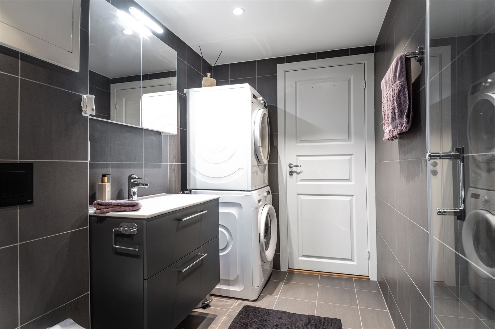 Innredningen består av stor dusjnisje med glassdører, toalett, servantskap og speilskap. Videre er det opplegg for vaskemaskin og tørketrommel. Galleribilde