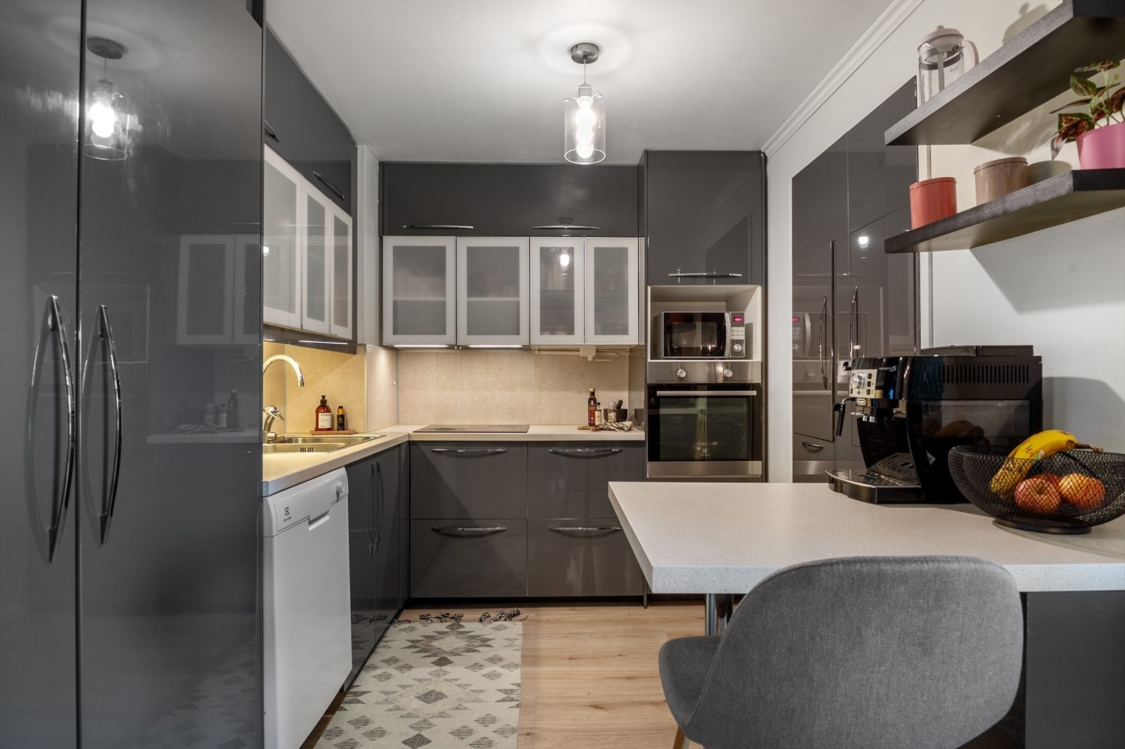 Stue og kjøkken er delt av en praktisk kjøkkenhalvøy med plass til barstoler og oppbevaring i skuffer. Galleribilde