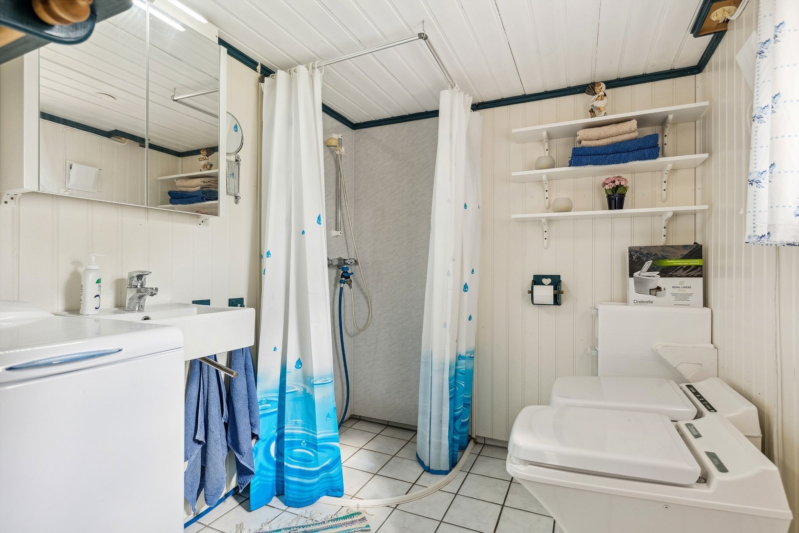 Dette er et enklere bad med fliser på gulv og baderomsplater i dusjhjørne og panel på de resterende veggene. Galleribilde