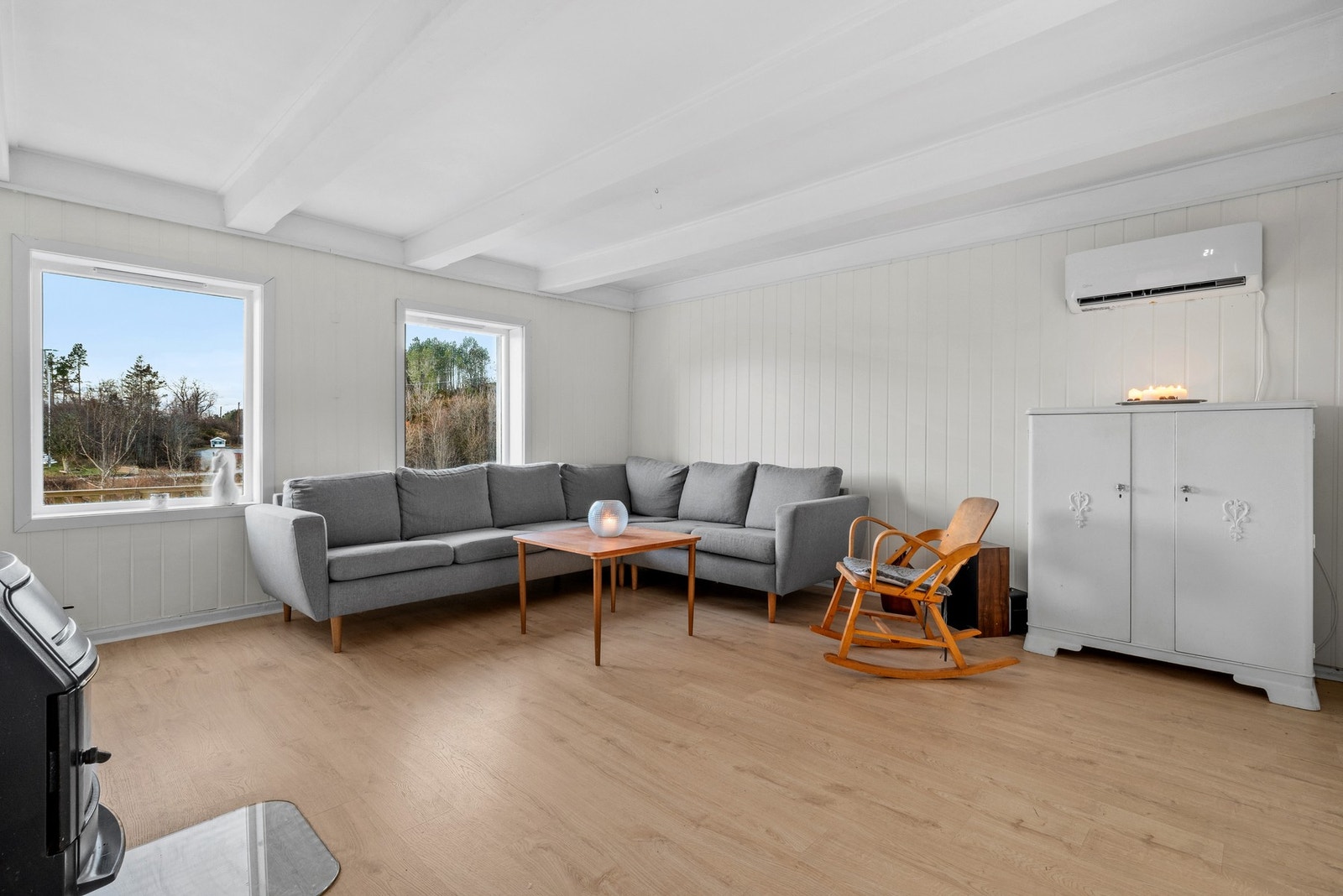 Atmosfæren i hovedstuen er lun og god, med både vedovn og varmepumpe montert. Galleribilde