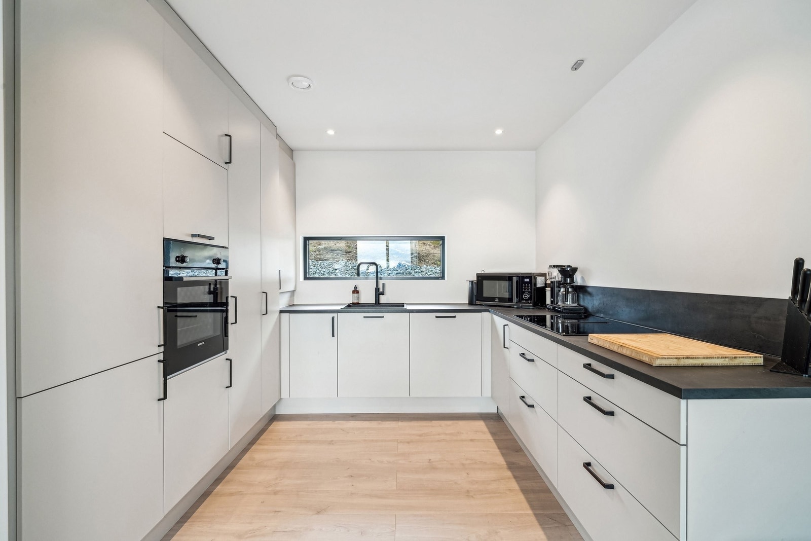 Kjøkken fra HTH med integrerte hvitevarer fra Siemens. Nedfelt ventilator i koketopp. Galleribilde