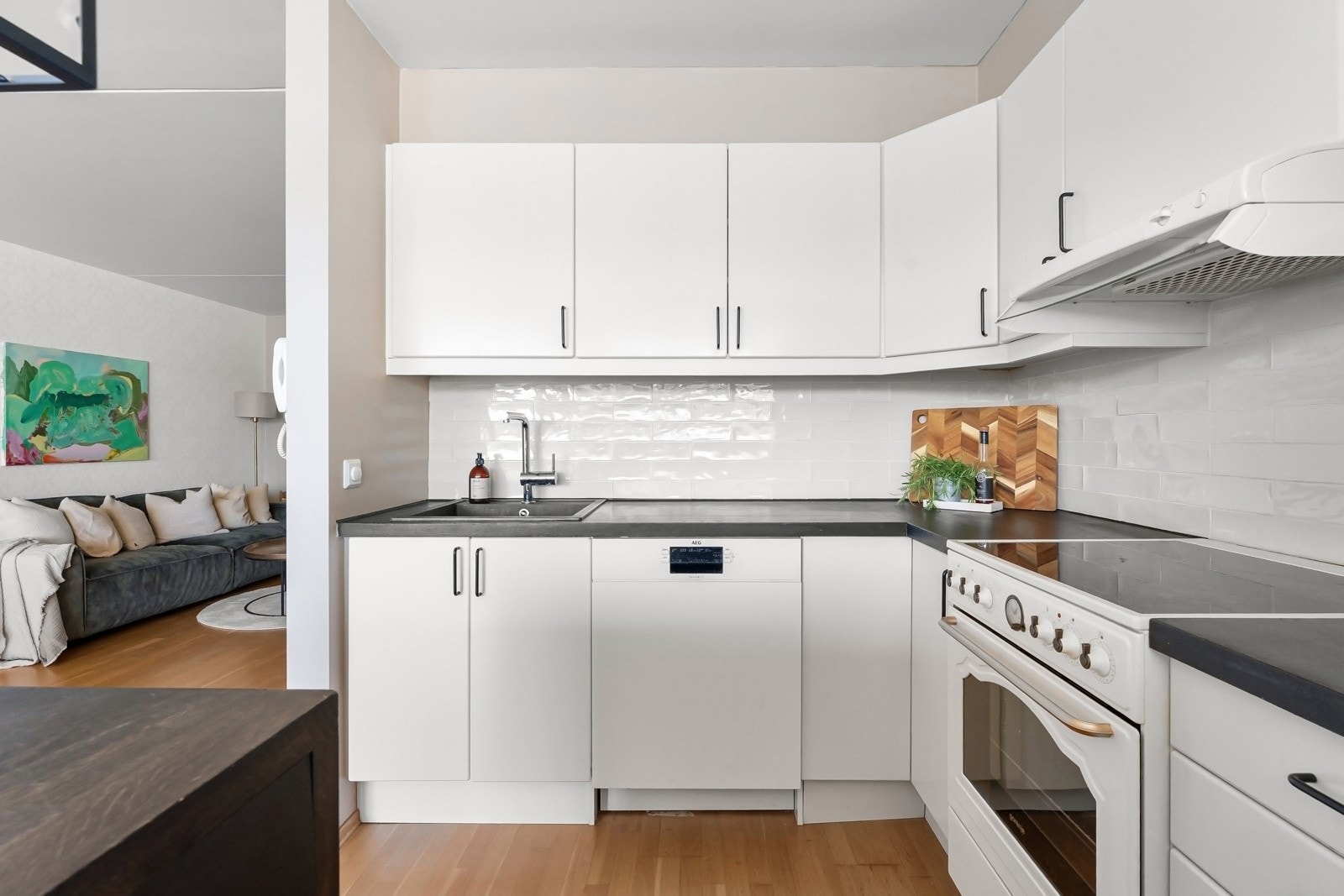 Innredningen har glatte fronter og en heltre benkeplate med nedfelt kum, som ble slipt ned og beiset i 2022. Kjøkkenet er utstyrt med frittstående hvitevarer, inkludert stekeovn, kjøleskap og oppvaskmaskin Galleribilde