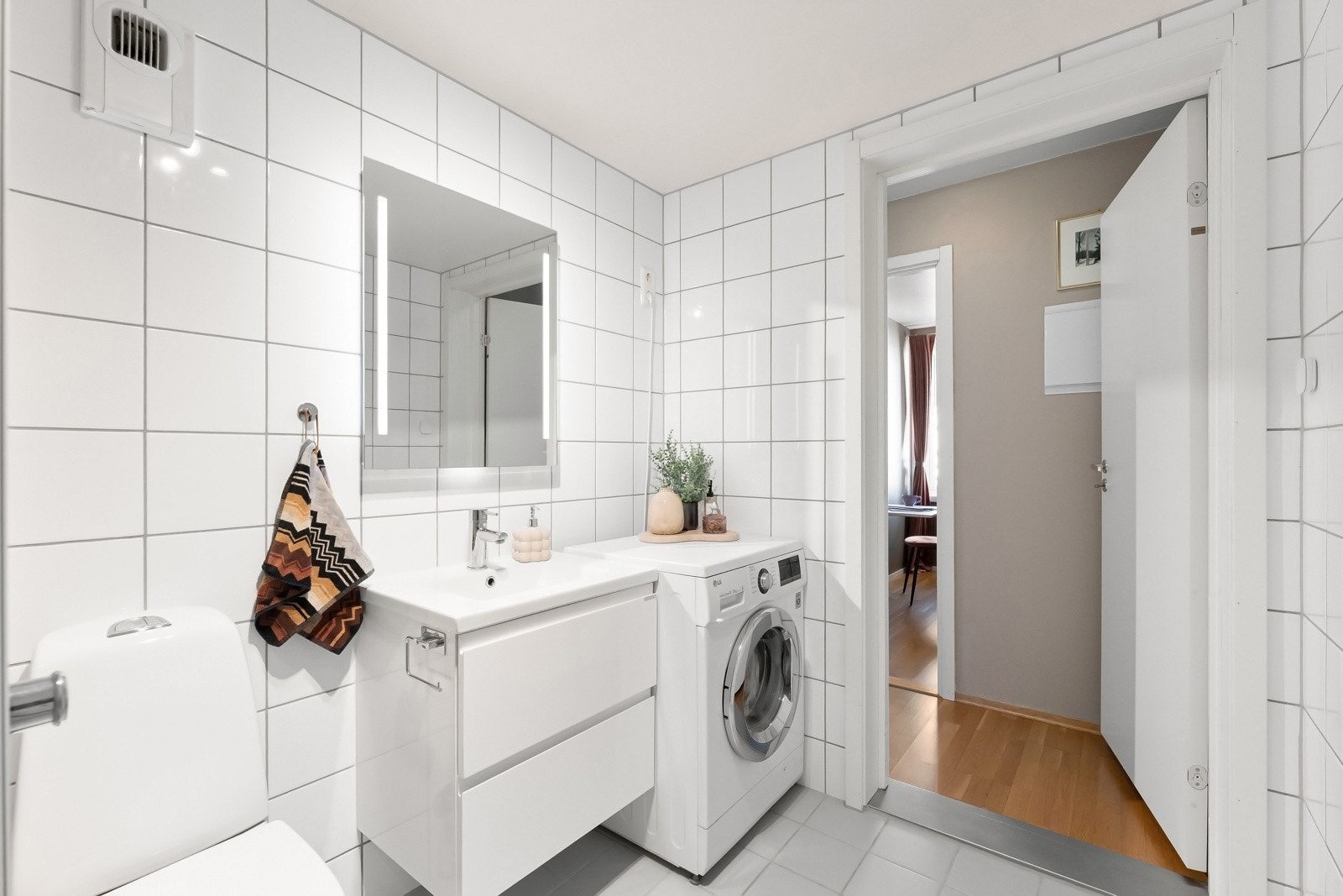 Innredningen er fra VikingBad og inkluderer servantskap, speil med justerbar belysning og integrert stikkontakt. Rommet er videre utstyrt med dusjhjørne, toalett og vaskemaksin Galleribilde