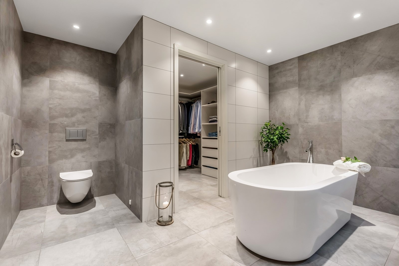 Midt i rommet står et herlig badekar for stunder med god tid. Praktisk tilknyttet badet er et innredet omkledningsrom. Galleribilde