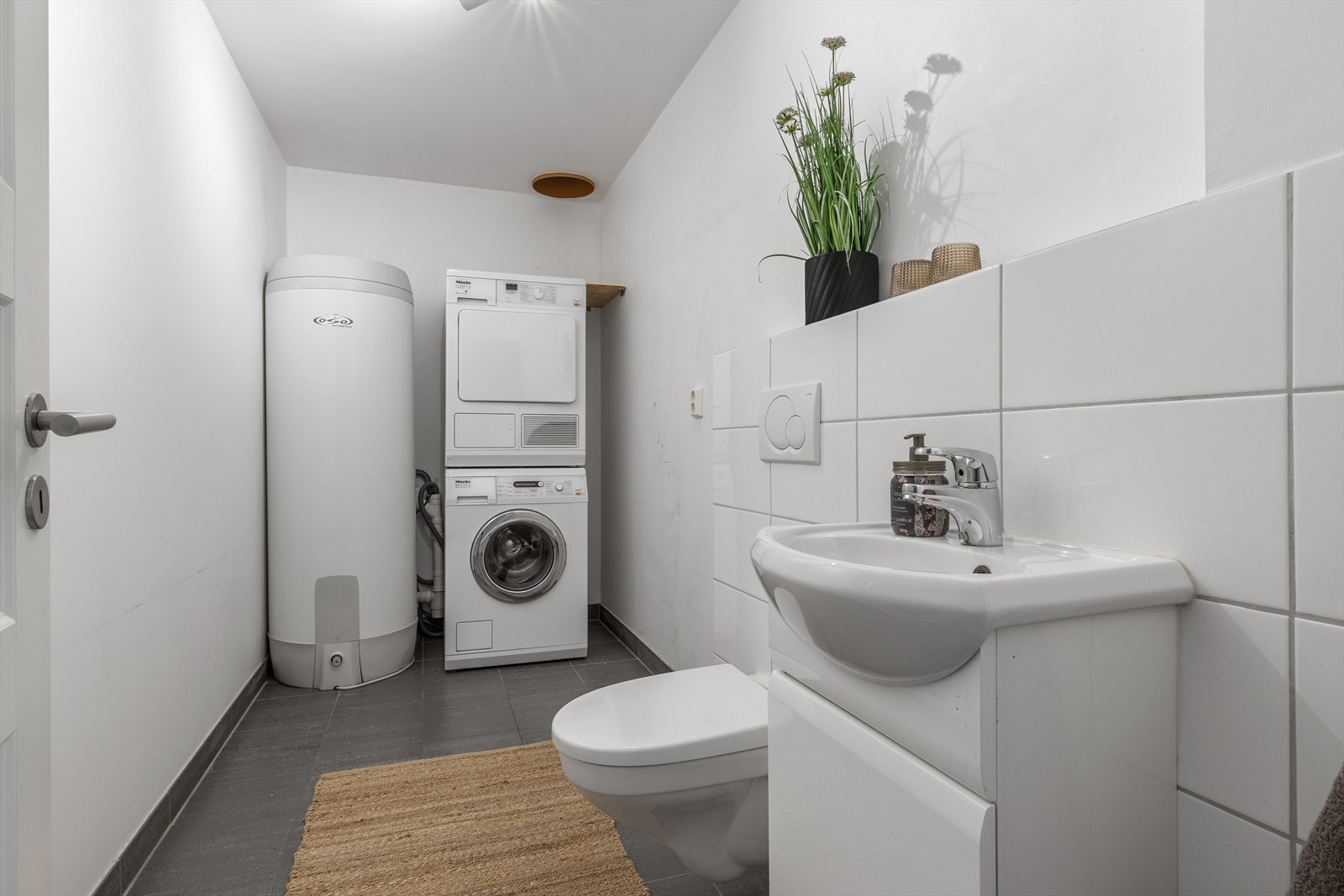 Ved siden av hovedbadet ligger et praktisk vaskerom med toalett, servantskap og opplegg for vaskemaskin. Galleribilde