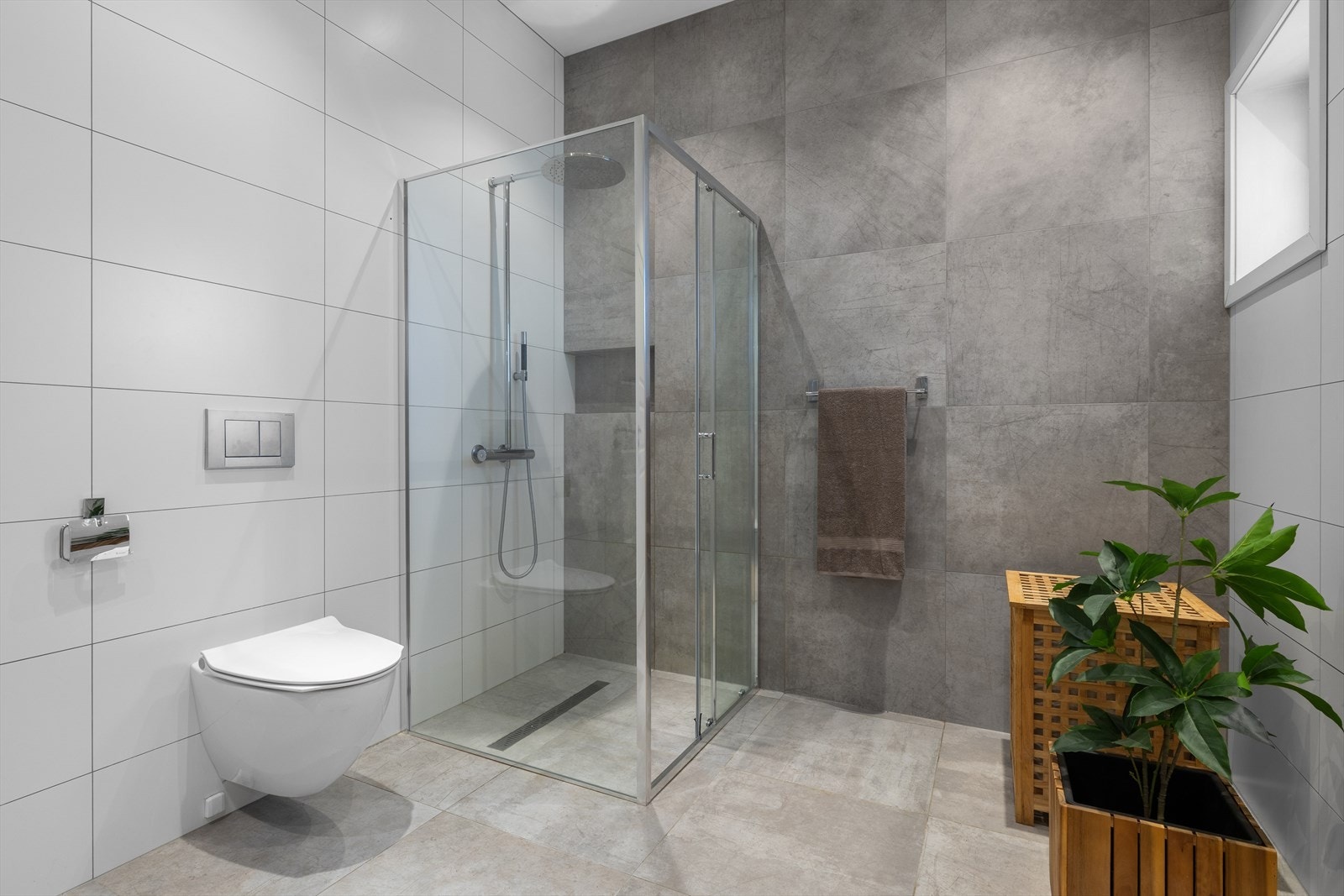 Et av boligens fire bad er praktisk plassert med tilgang fra hall i 1.etasje, med blant annet vegghengt toalett og nedfelt dusjnisje med regnfallsdusj og skyvedør i glass. Galleribilde