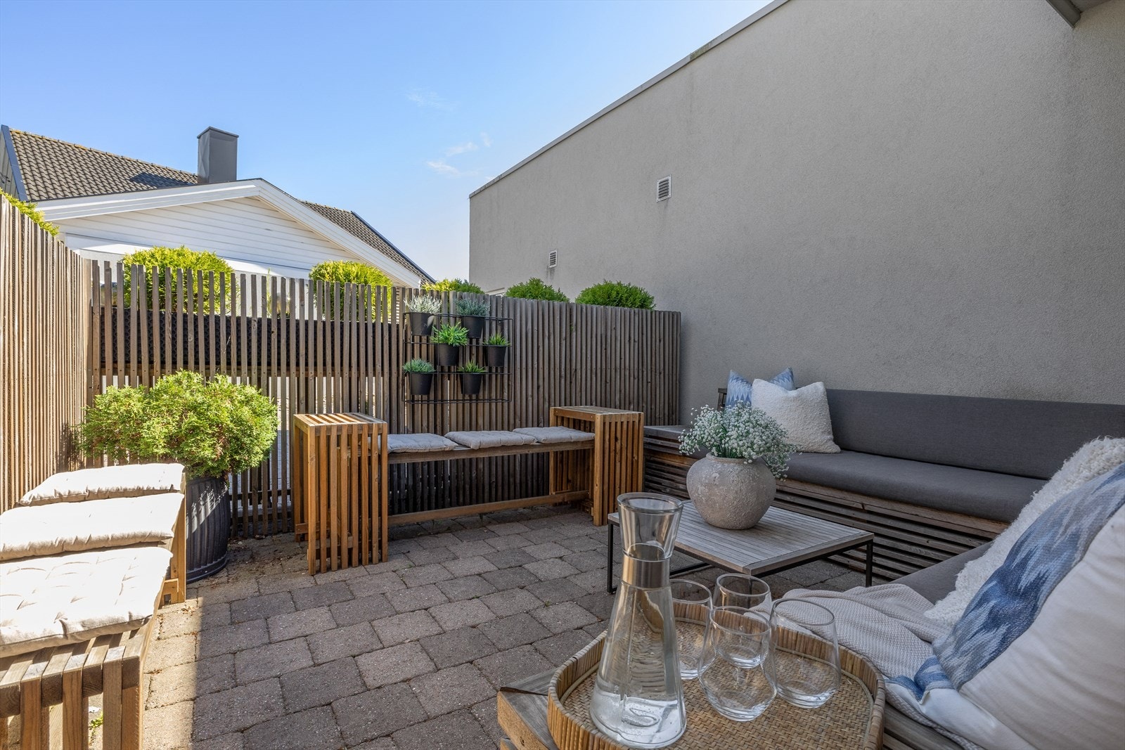 Ved inngangspartiet er det en liten, koselig plass inngjerdet med plantekasser og spilevegg. Galleribilde