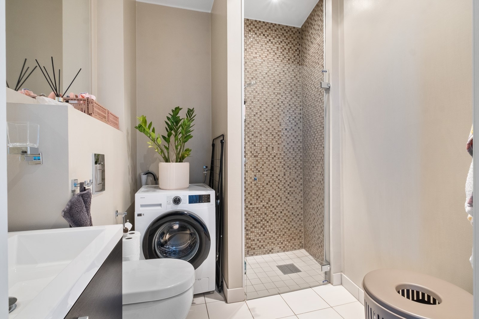 Pent, flislagt baderom fra 2012 med varme i gulvet og downlights i himling. Baderommet er innredet med vegghengt klosett, servant med innredning, innfelt speil og dusjhjørne med svingbar glassdør. Opplegg for vaskemaskin. Mekanisk avtrekk. Galleribilde