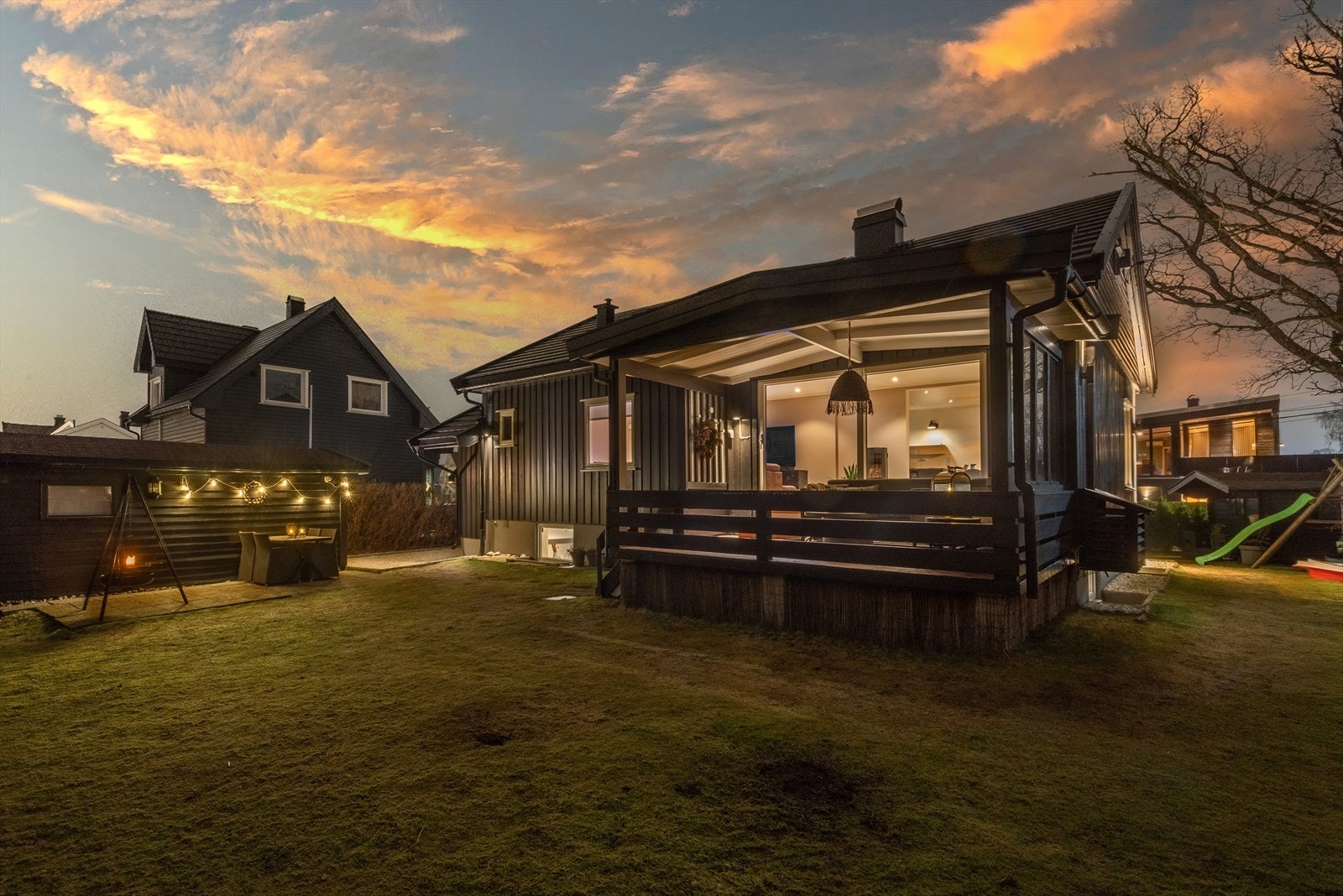 Fra veranda fører en trapp videre ned til hage med rom for aktivitet for små og store. Galleribilde