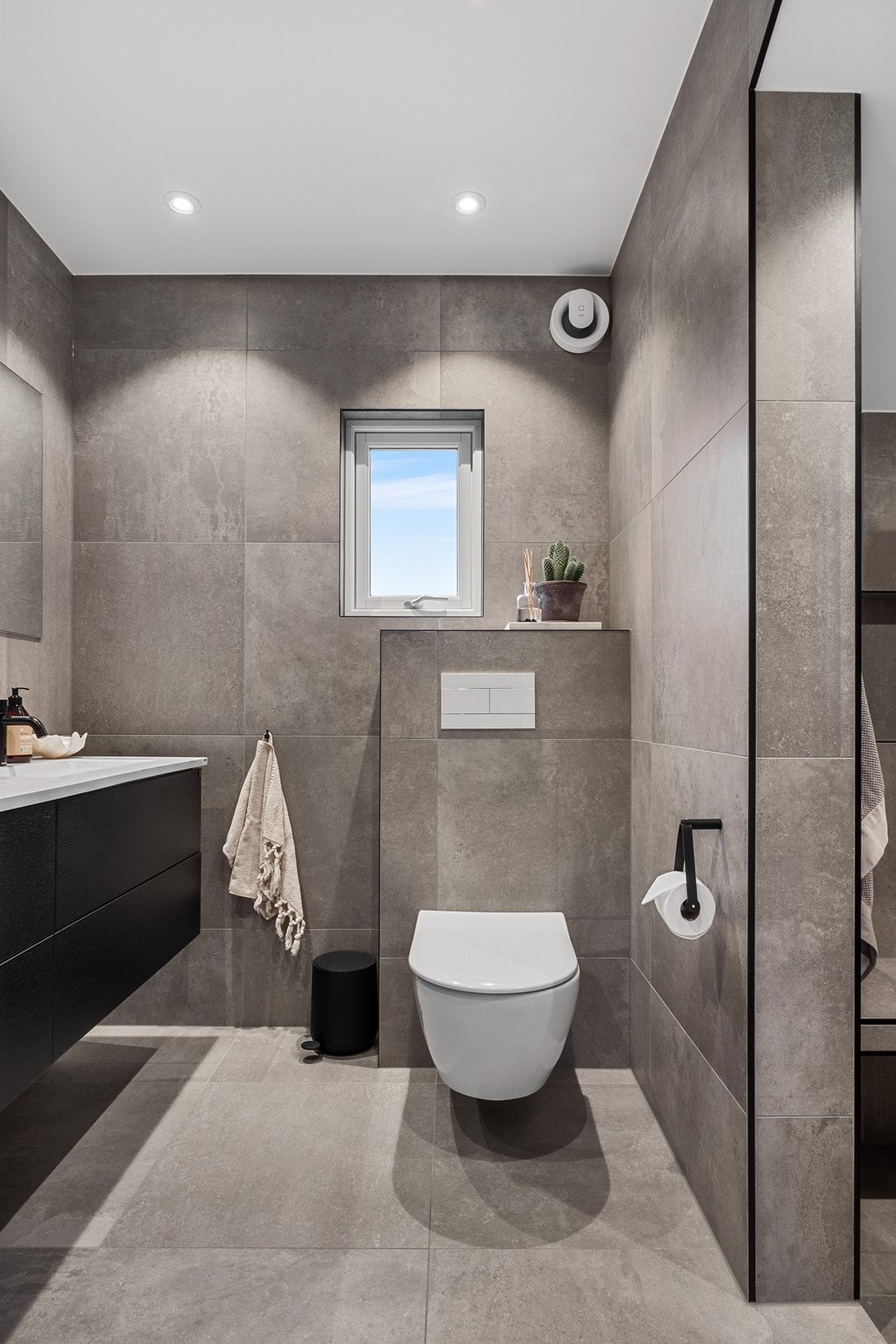 Badet fra 2021 er stilrent og tiltalende, med store fliser, varmekabler og downlights. Galleribilde