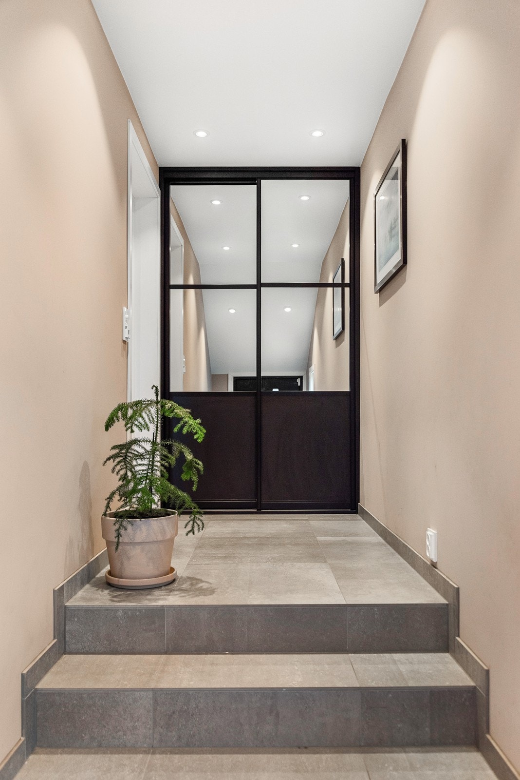 I toppen av trappen i entreen er det skyvedørsgarderobe for oppbevaring. Galleribilde