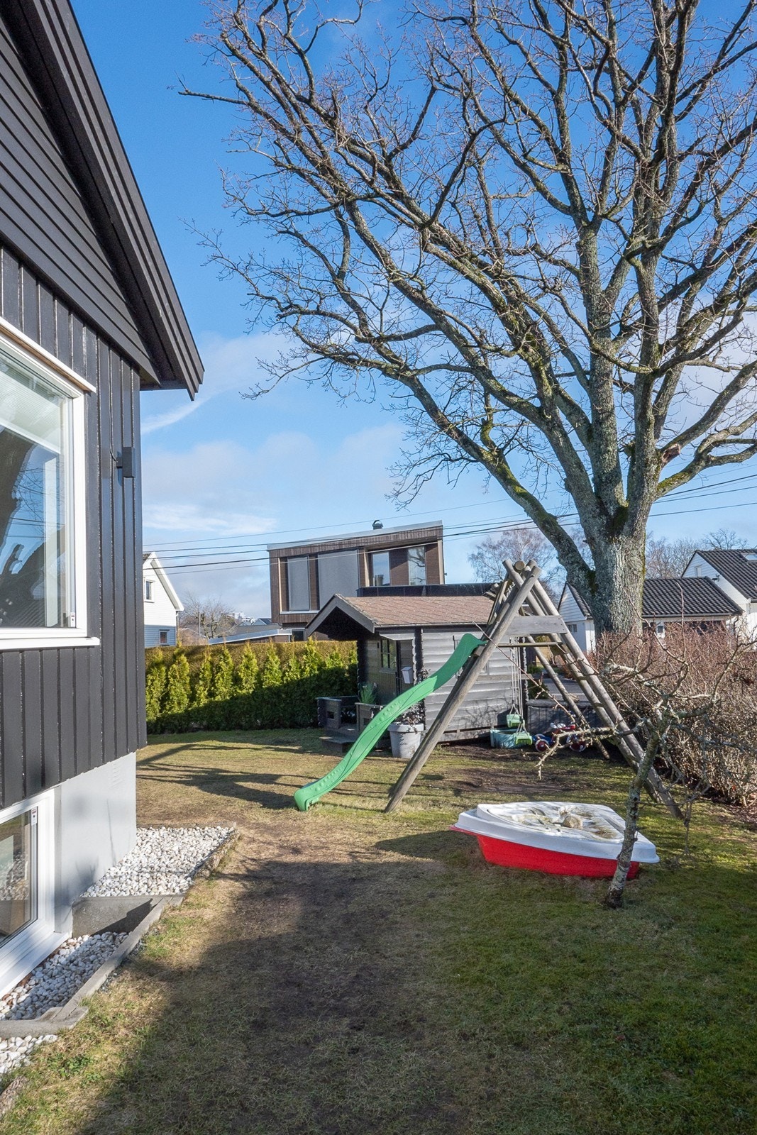 Uteområdet er opparbeidet med gressplen og div. beplantning, samt en lekestue på fremsiden. Galleribilde