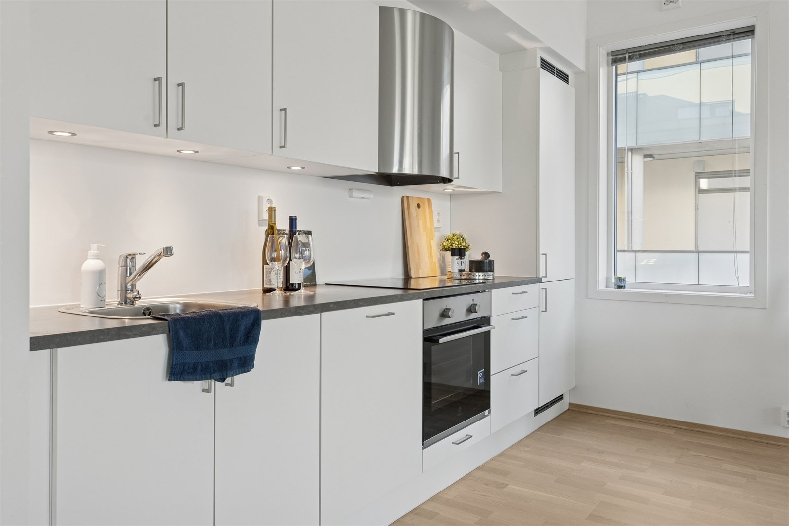 Kjøkkenet er lyst og moderne, med integrerte hvitevarer, god benkeplass og mye lagringsplass i overskap og skuffer. Galleribilde