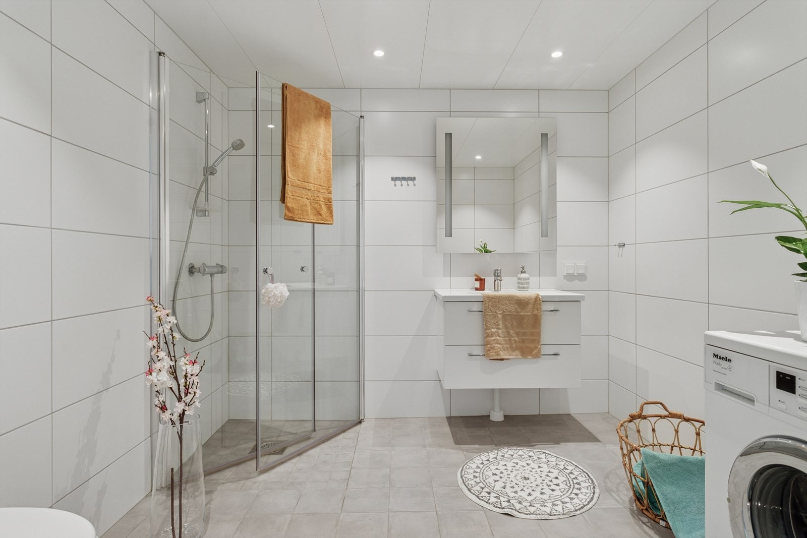 Baderommet er flislagt med varmekabler og har opplegg for vaskemaskin. Vegghengt WC og dusj med innfellbare dører. Galleribilde