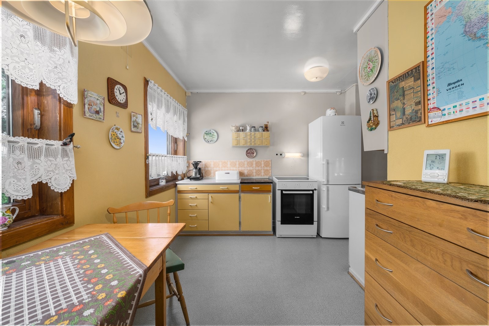 Boligen har et eldre kjøkken, og dagens kjøkkeninnredning har benke- og overskap med slette fronter, benkeplate av laminat og fliser på vegg over benk. Galleribilde