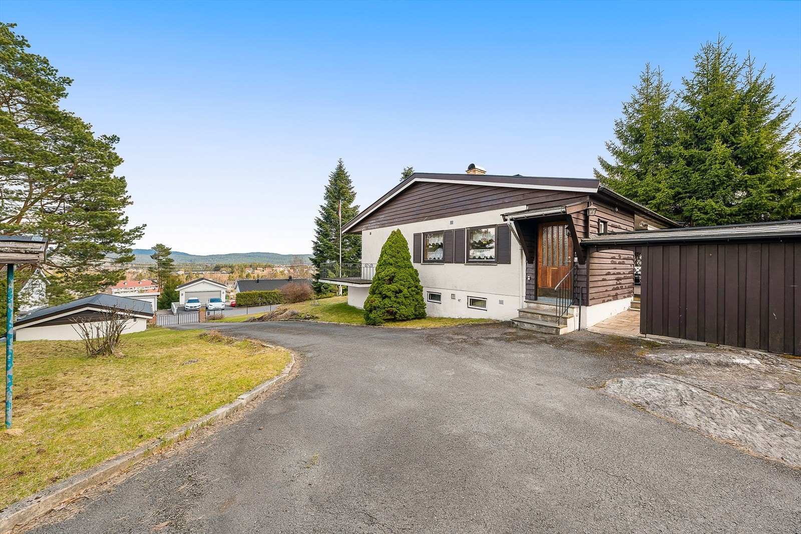 Asfaltert gårdsplass med varmekabler på den ene siden av oppkjørselen. Galleribilde