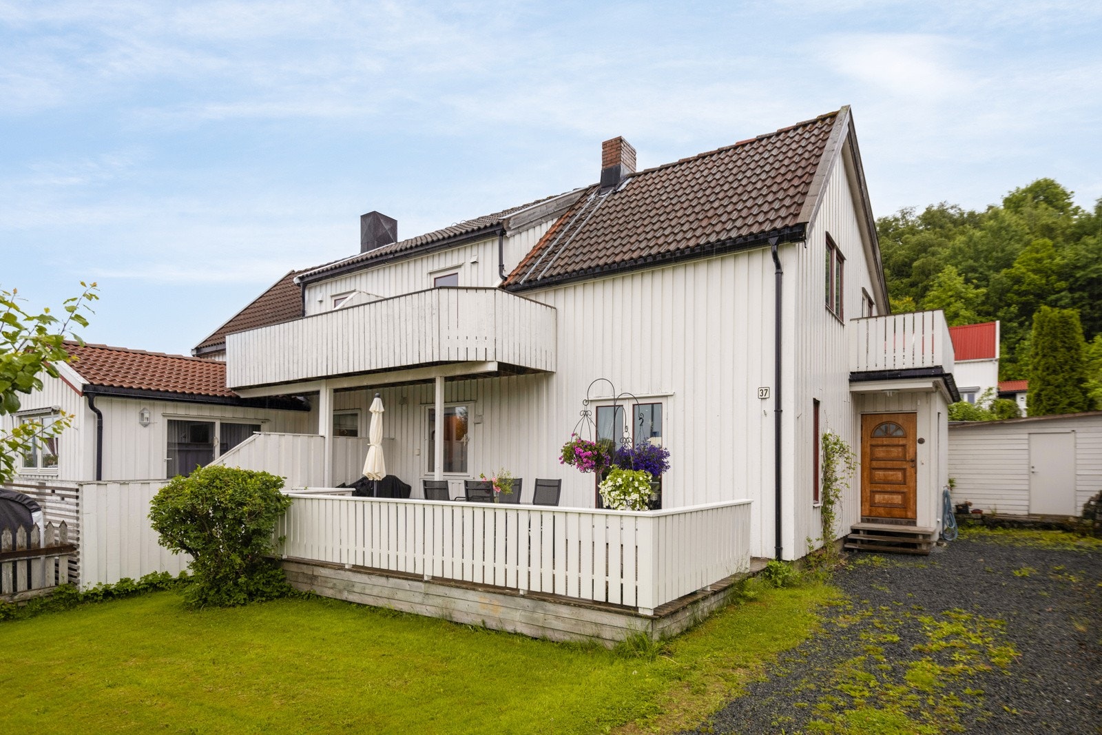 Tilbaketrukket beliggenhet på tomten og fin hage mot veien. Galleribilde