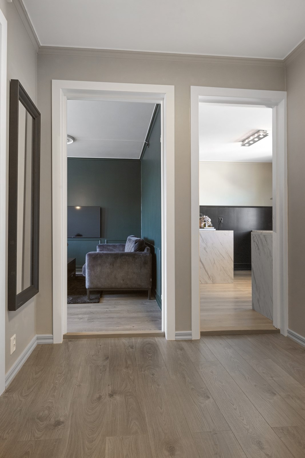 Det første som møter deg i boligen er en romslig og funksjonell gang med god plass til organisering av yttertøy. Gangen er malt i lys gråfarge som skaper et lyst og åpent rom som inviterer deg videre inn i boligen. Galleribilde