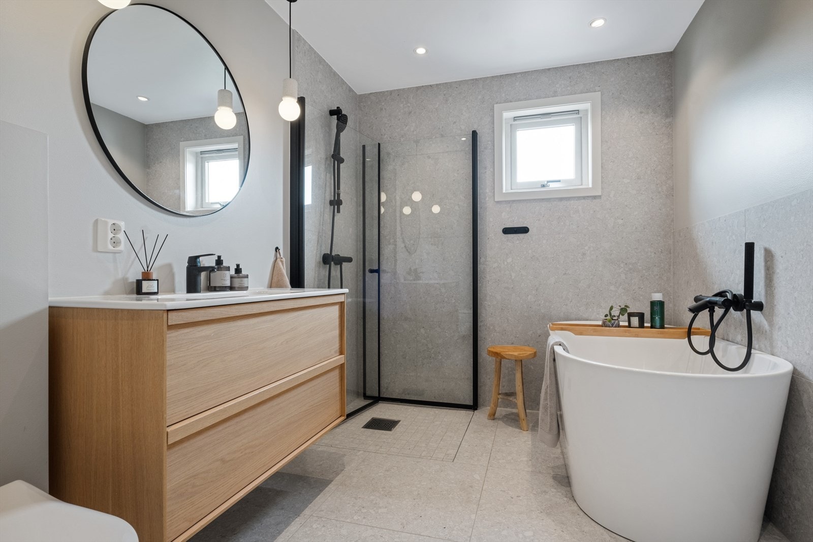 Moderne og lekkert bad fra 2022 med delvis flislagte og slette vegger. Det er fliser på gulv med varmekabler og downlights i himling. Innerst i rommet finner man et romslig dusjhjørne med håndholdt spylefunksjon. Galleribilde