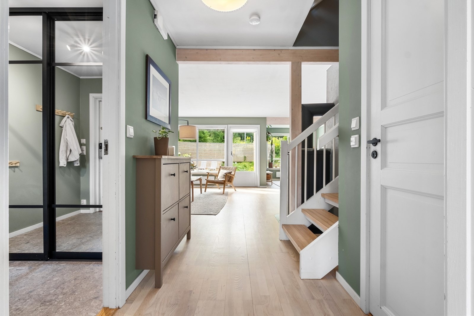 Fra en flott steinbelagt gårdsplass kommer du inn til en stilren og innbydende yttergang med fliser. Galleribilde