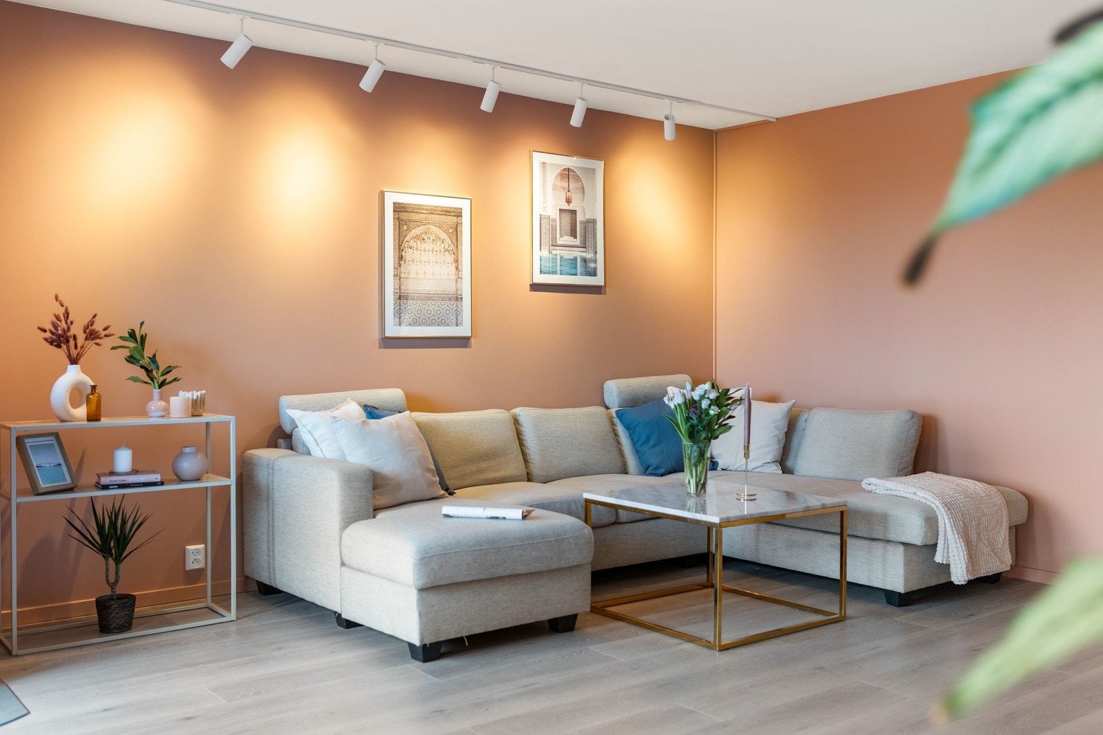 Lys stue med varme farger på veggene. Spotbelysning i taket. Galleribilde