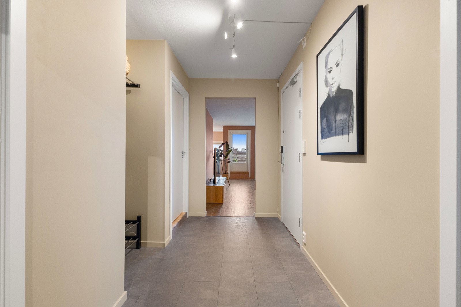 Lys gang med flislagt gulv og beige vegger. Her har du også mulighet til å sette inn skyvedørsgarderobe. Galleribilde