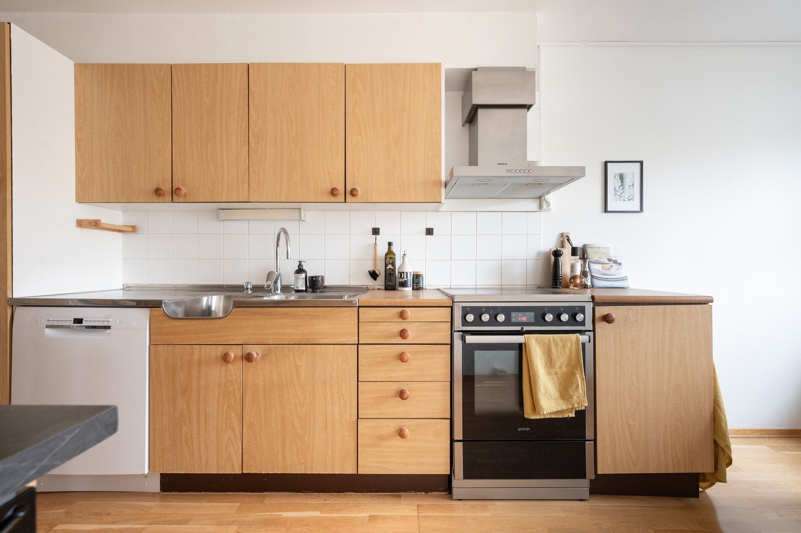 Kjøkken med spiseplass og vaskeromsdel. Innredning er gammel. Galleribilde