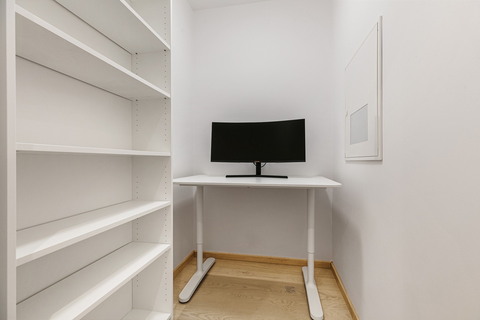 En bod ved entré er i dag innredet som kontor med arbeidspult og hyllesystem Galleribilde