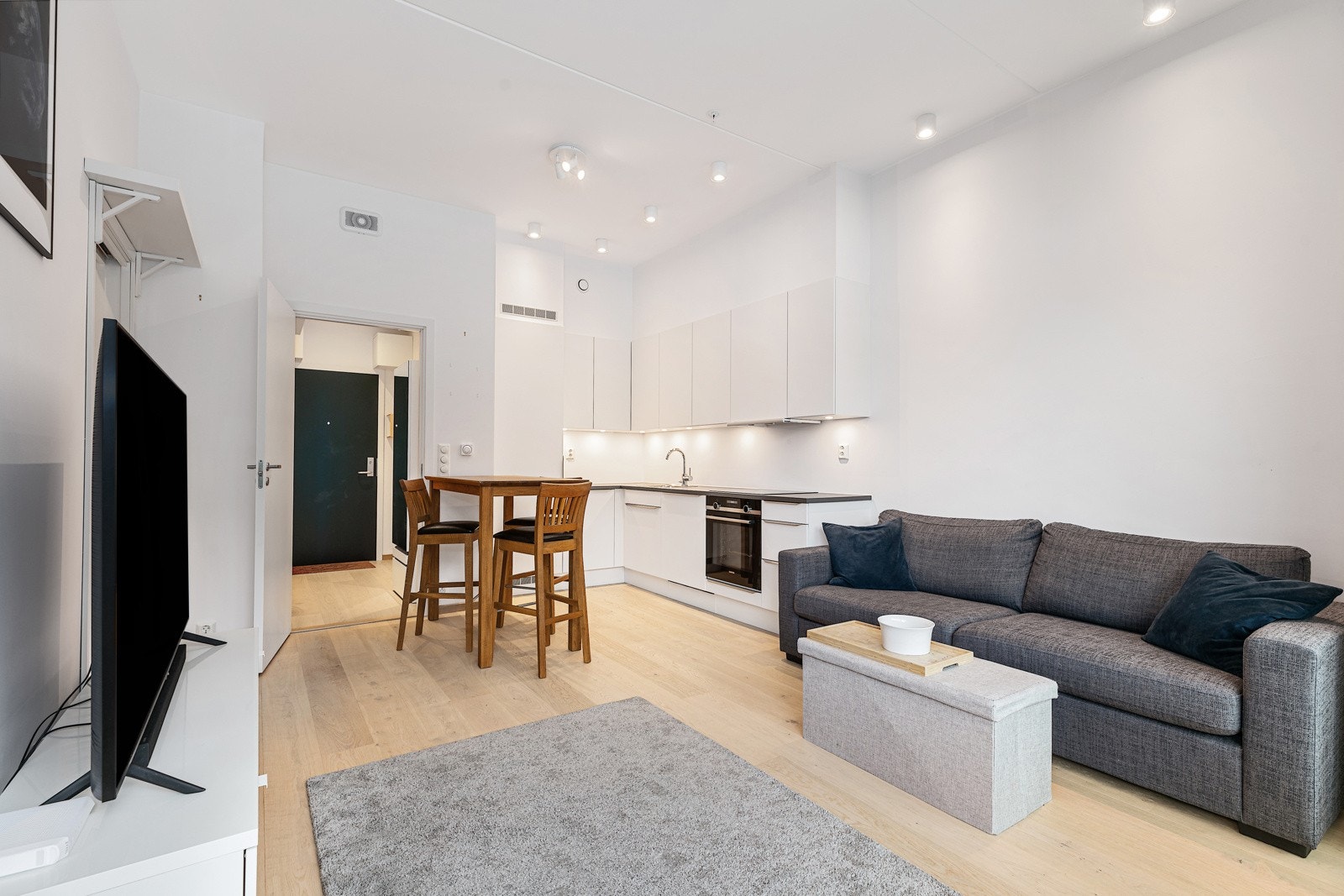 Stue og kjøkken i åpen løsning gir rom for en spiseplass ved kjøkken Galleribilde