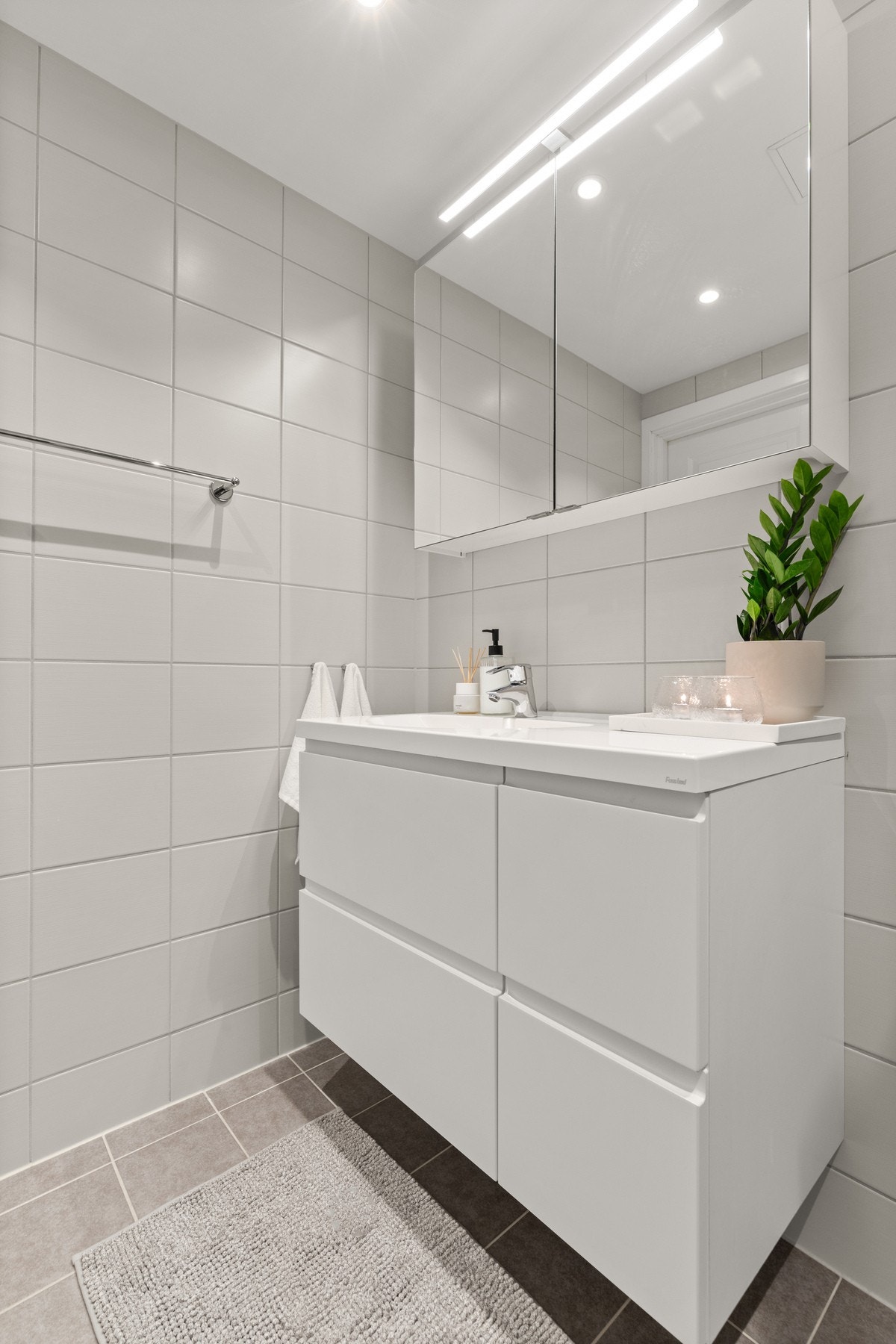 Badet er innredet i tidløse grå og hvite toner, som gir en behagelig start på dagen og har romslig innredning Galleribilde