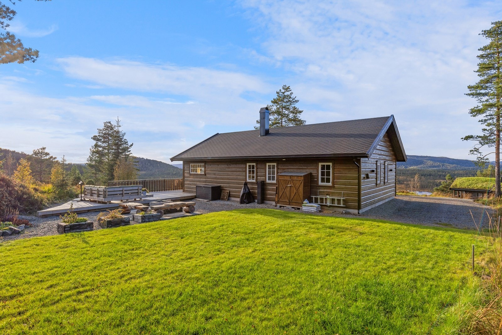 Hyggelige uteområder rundt hytta med plen og terrasse Galleribilde