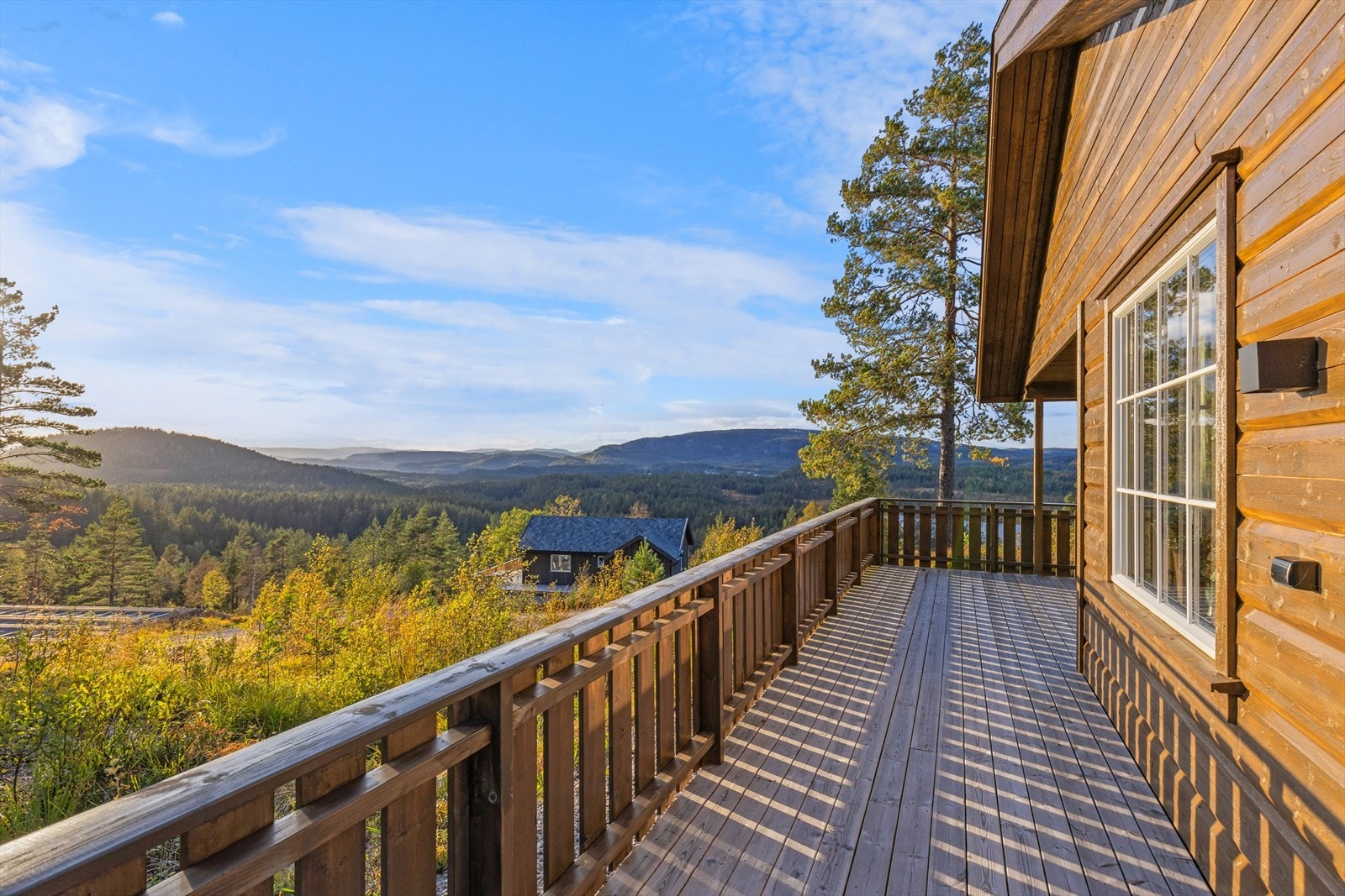 Terrassen strekker seg rundt deler av hytta og det er god plass til sittegruppe Galleribilde