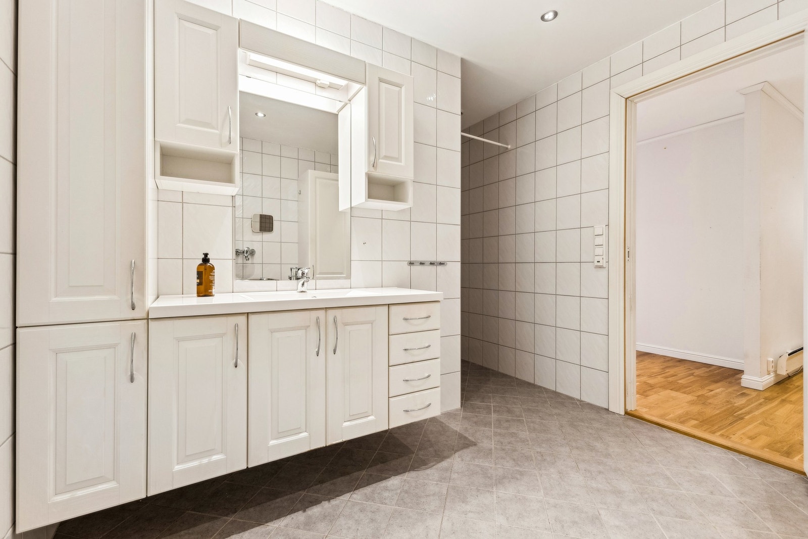 Badet er av en god størrelse med flislagt gulv, opplegg til vaskemaskin og tørketrommel, samt dusjhjørne. Galleribilde