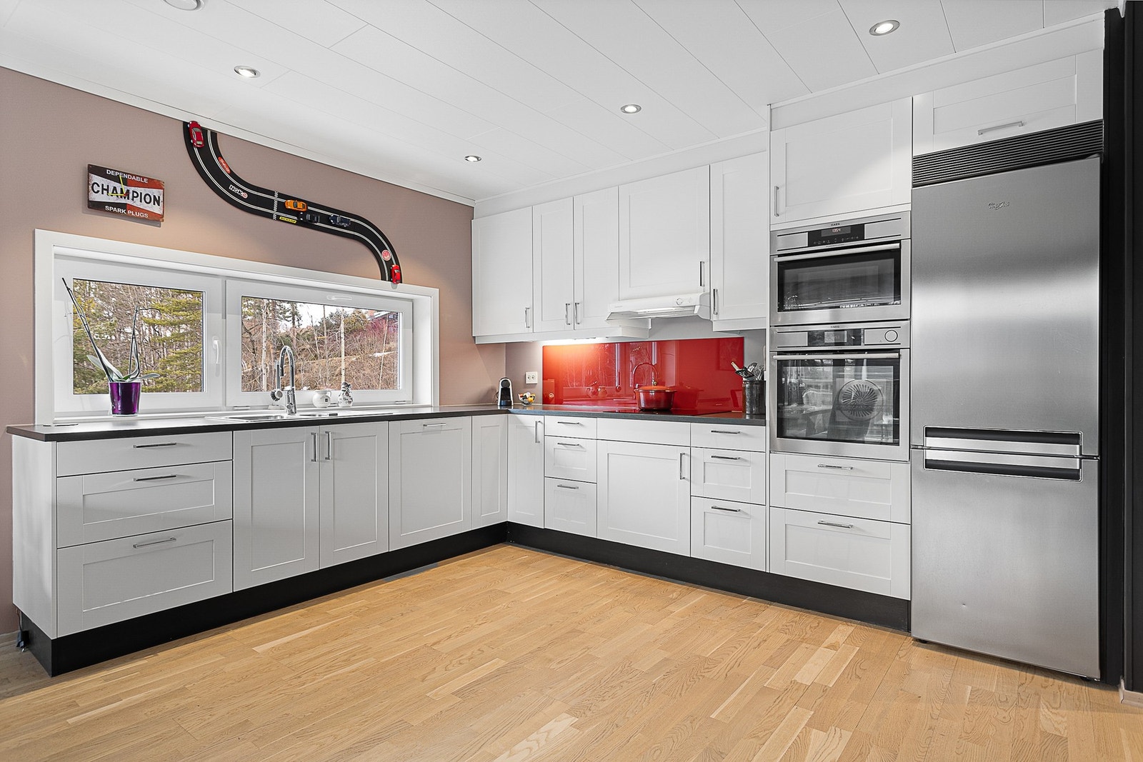 Kjøkkenet inneholder hvitevarer som kjøleskap, stekeovn, micro, platetopp og oppvaskmaskin. Galleribilde