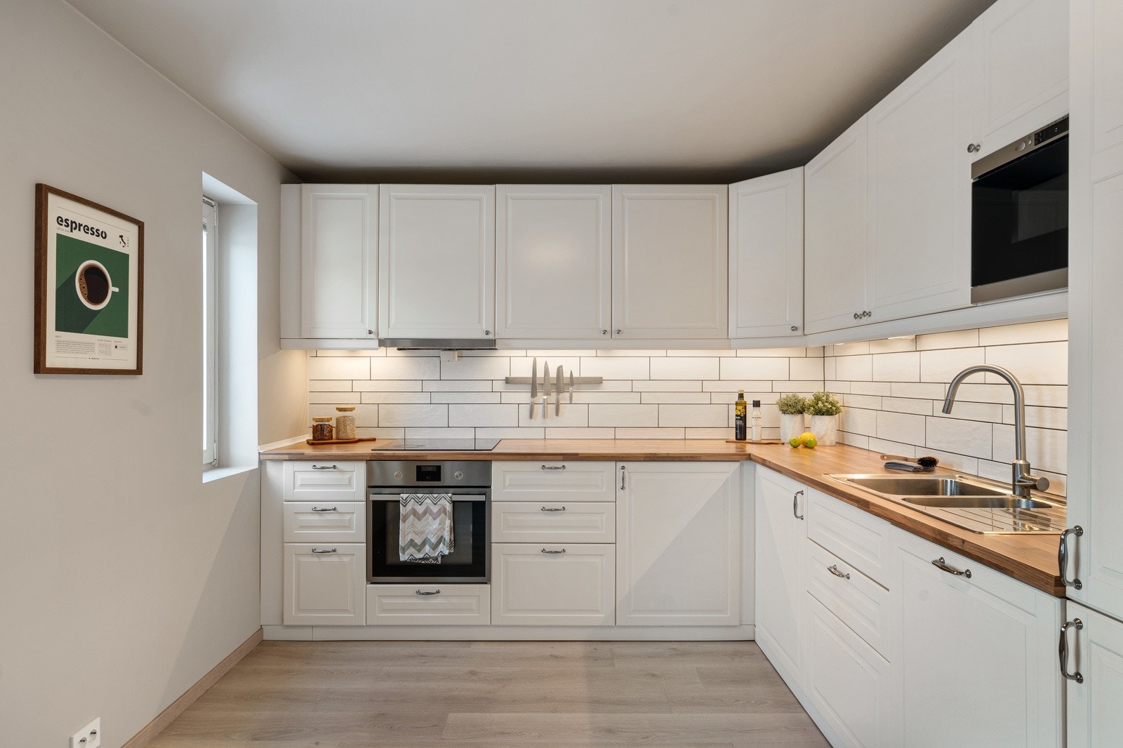 Innredningen er tidløs med profilerte fronter, laminert benkeplate og integrerte hvitevarer i form av stekeovn, platetopp, mikroovn, oppvaskmaskin og kombiskap. Galleribilde