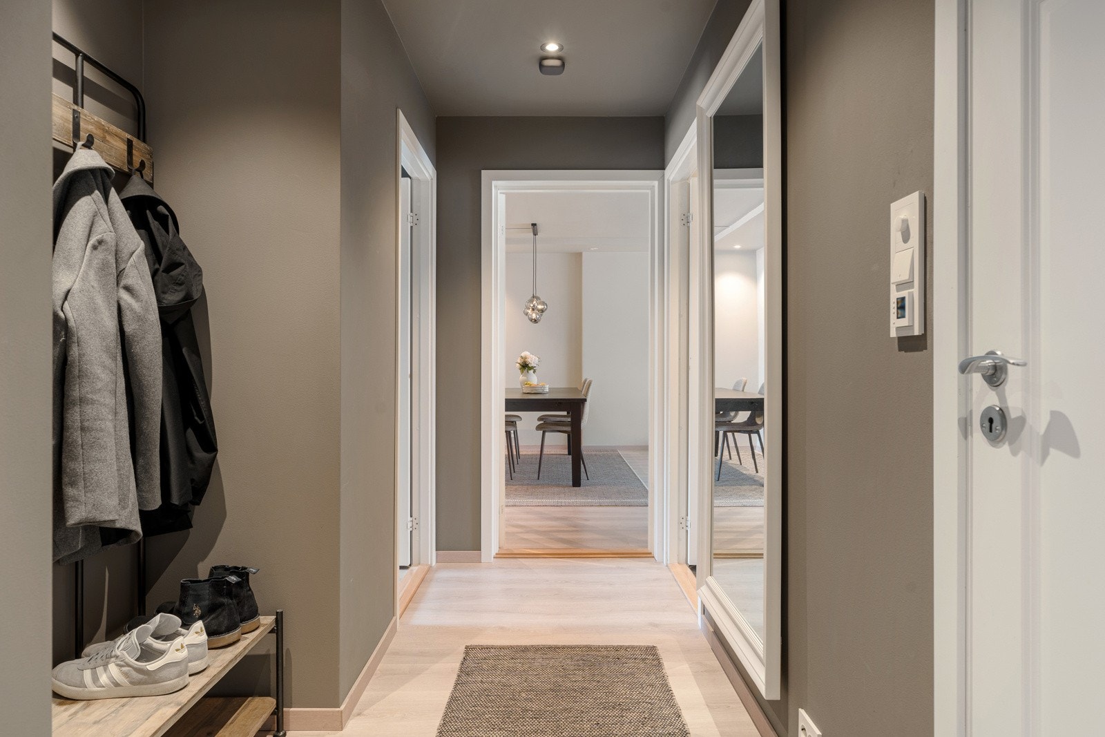 Entréen gir et utmerket førsteinntrykk med sin romslige utforming og behagelige fargepalett. Det er installert en masterbryter i gangen som kan skru all smartbelysning på eller av, samt styre varme i gulv der det er lagt varmefolie. Galleribilde