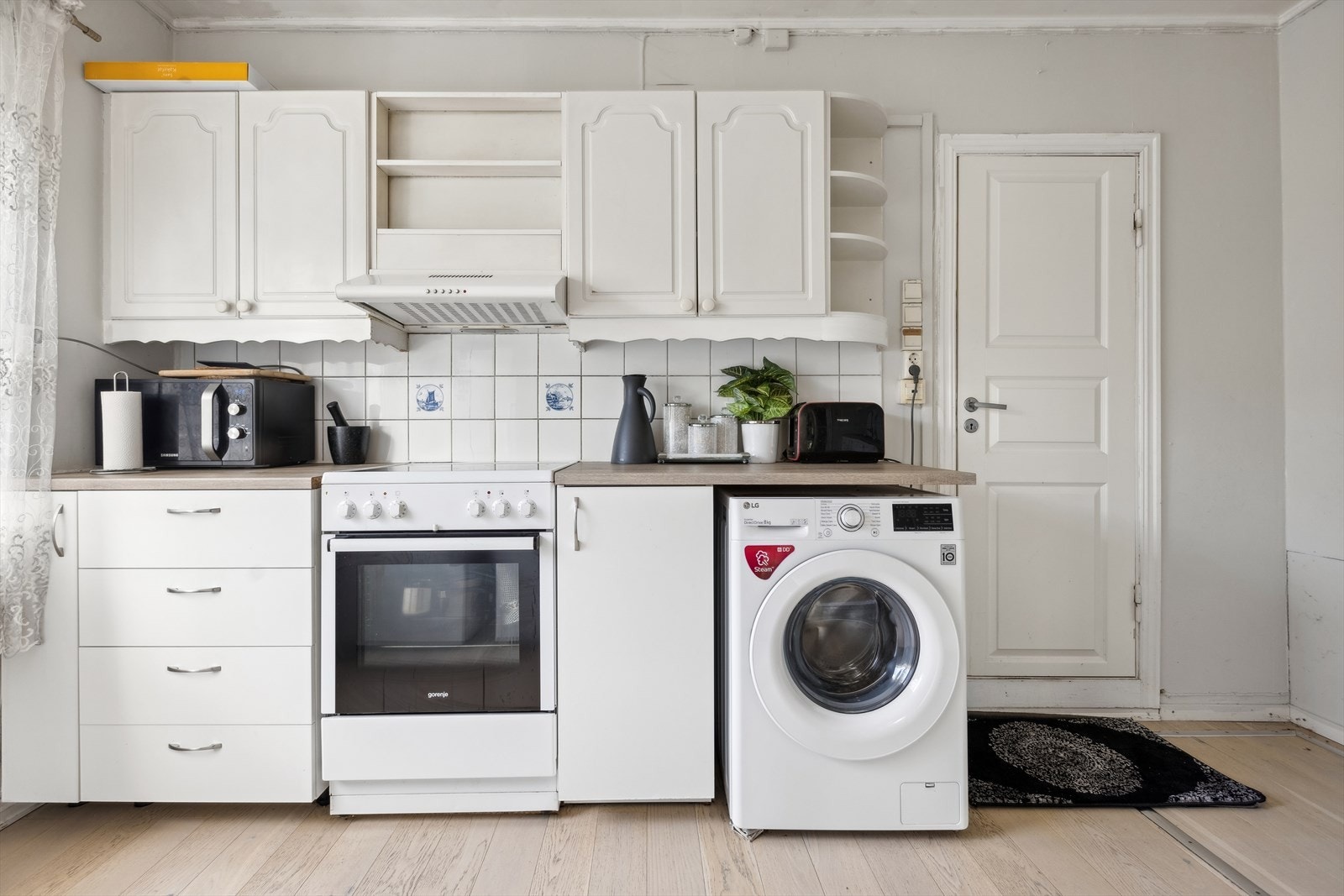 Kjøkkenet innehar fliser på vegg over benkeskap og laminat benkeplate med nedfelt kum i rustfritt stål. Galleribilde